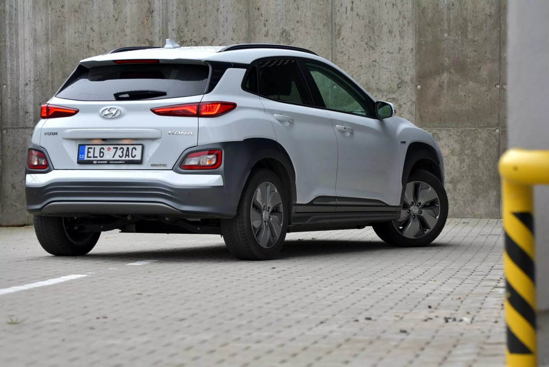 Hyundai Tucson 2021 argento catturato da un angolo posteriore di tre quarti, che mostra il portellone, la ruota posteriore sinistra e il lato del corpo con fanale posteriore visibile, logo Hyundai e iscrizione TUCSON, incluso tergicristallo posteriore, antenna a pinna di squalo e design della ruota in lega.
