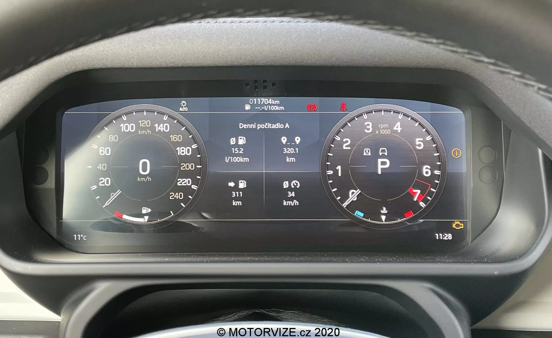 Vista ravvicinata dalla parte anteriore del cruscotto digitale del Land Rover Defender 2020 con un grande tachimetro circolare (0-260 km/h) e contagiri (0-8,000 RPM), integrazione di vari indicatori di stato del veicolo e informazioni dettagliate tra cui indicatore del carburante, temperatura, contachilometri (117,706 km), contatore giornaliero, consumo medio di carburante (0,9 L/100km), velocità media (32,1 km/h) e orologio digitale (11:28).