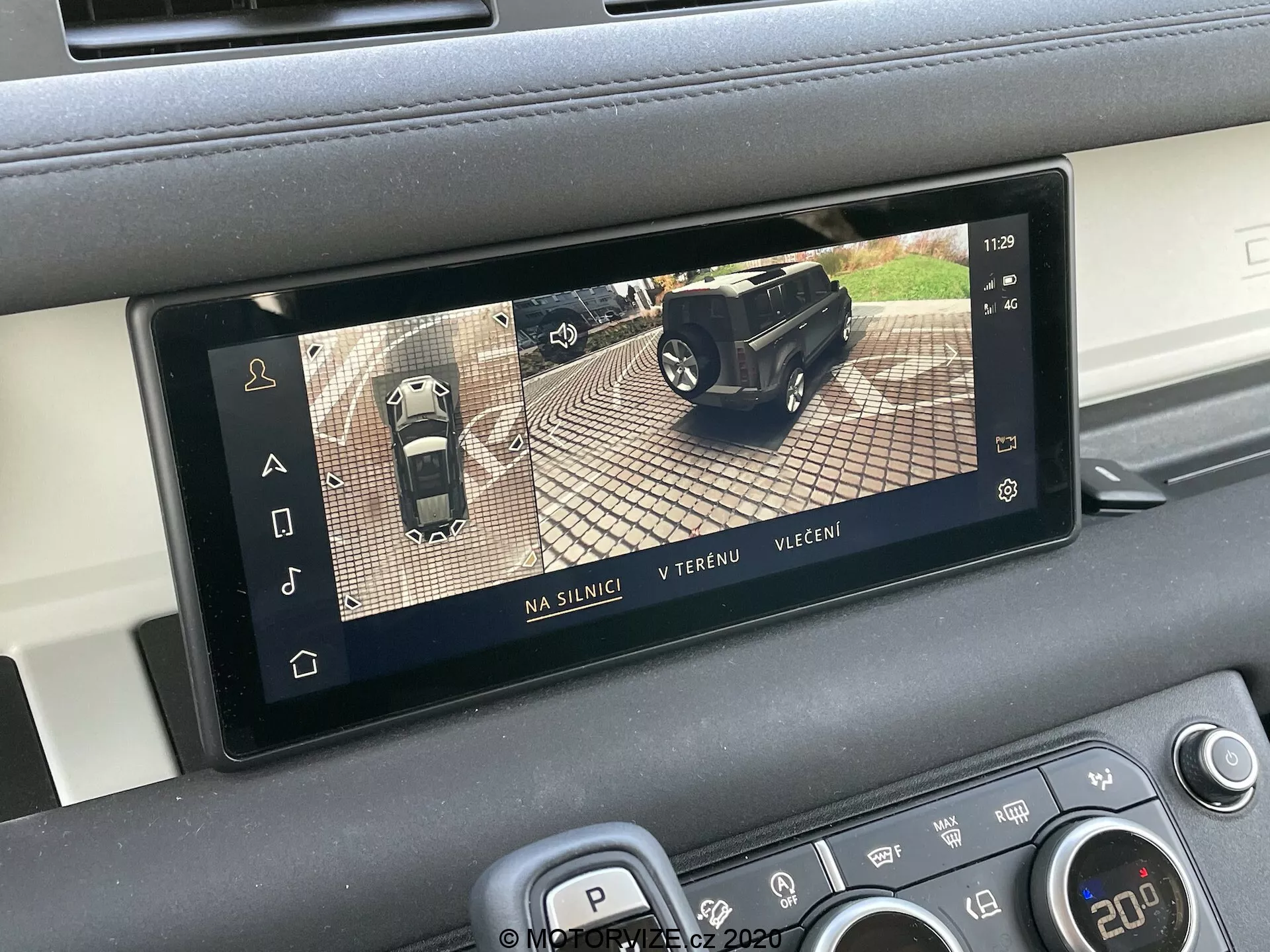 Display interno della Land Rover Defender 2020 che mostra un sistema di telecamera a vista dall'alto a 360 gradi, parte dei sistemi avanzati di assistenza alla guida (ADAS). Lo schermo rettangolare è integrato nella console centrale del veicolo e mostra tre modalità di visualizzazione: su strada, fuoristrada e serale. Il display aiuta con il parcheggio e le manovre combinando immagini da più telecamere intorno all'auto.