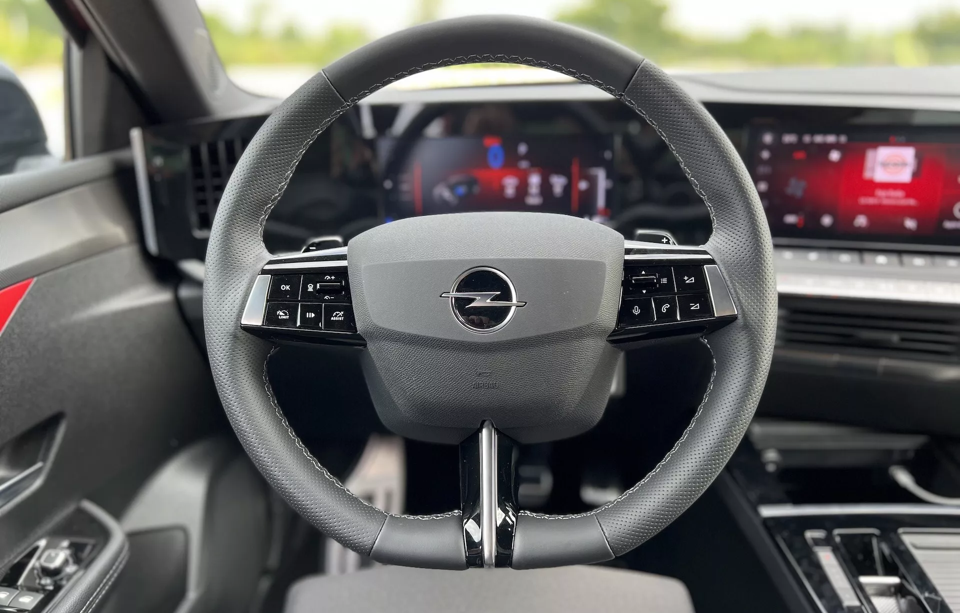 Vista interna dell'Opel Astra 2022 dal sedile del guidatore con focus sul volante multifunzionale moderno e sul cruscotto digitale