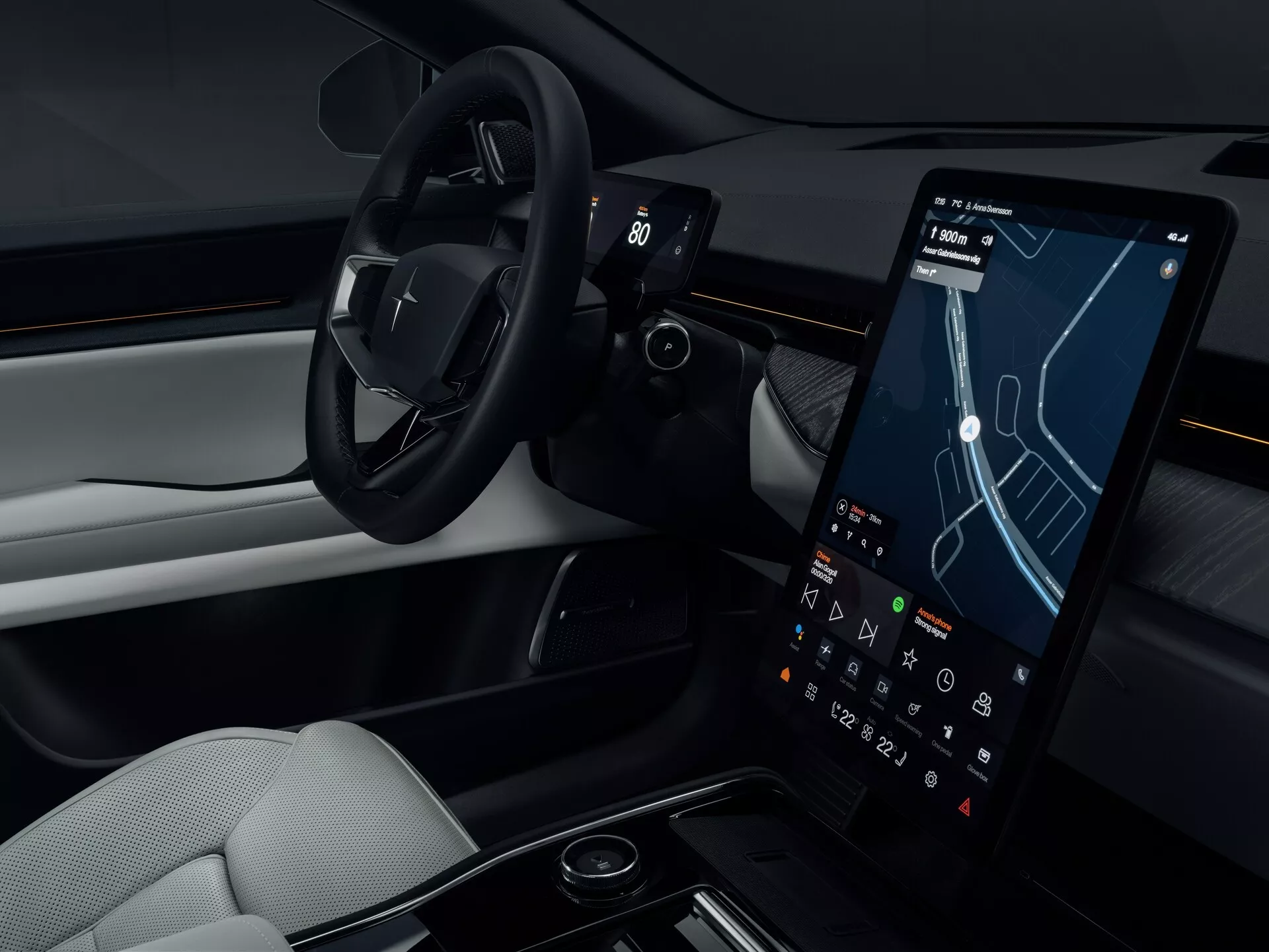 Interni della Polestar 3 2023 che mostrano l'area del conducente con volante minimalista, grande display touchscreen per navigazione e infotainment, design della cabina bicolore lussuoso e console centrale elegante
