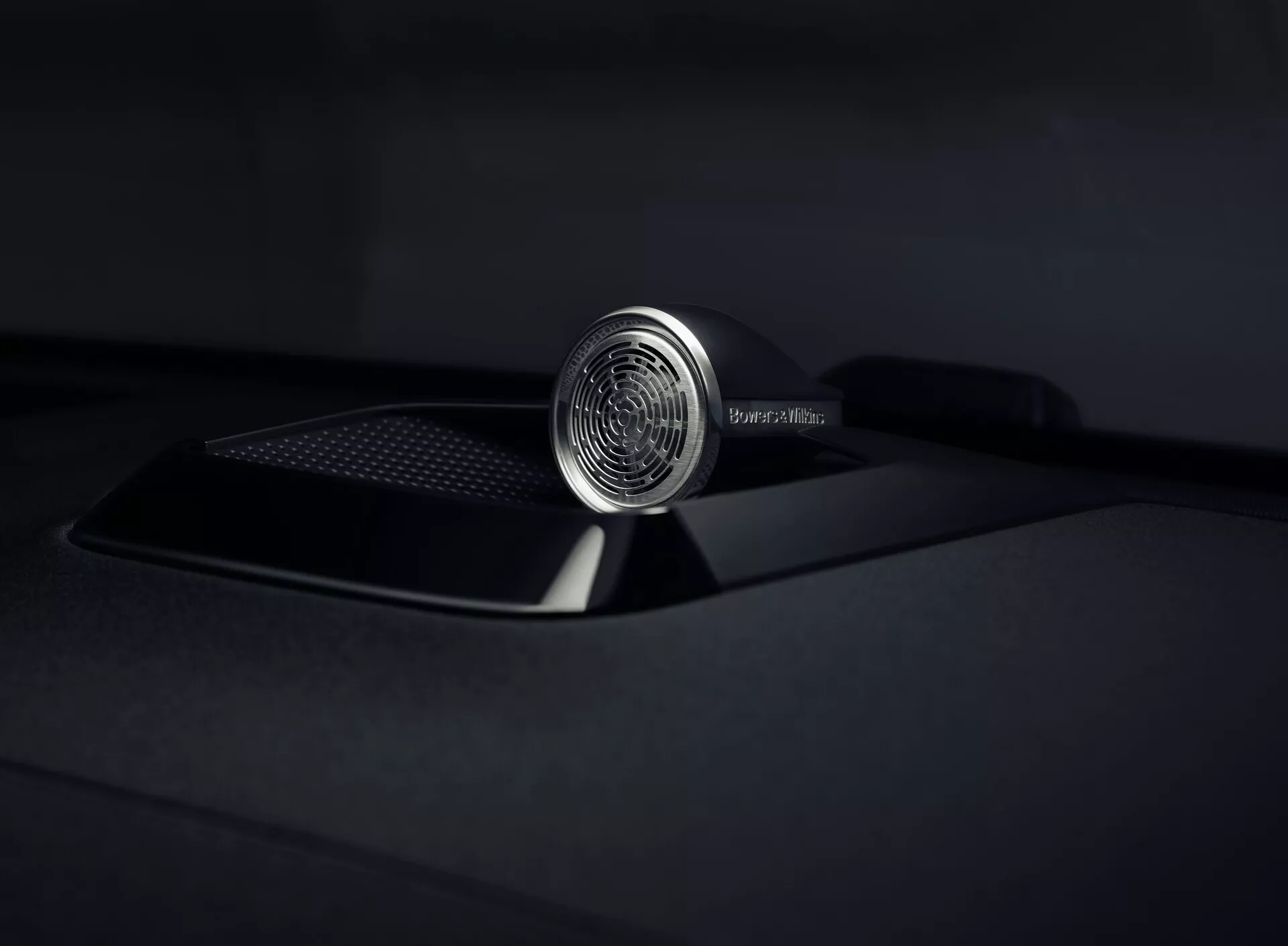 Vista ravvicinata dell'ornamento sul cofano del Polestar 3 2023 che enfatizza il suo design intricato e l'artigianato di lusso, con un emblema circolare dettagliato e un cofano nero opaco sofisticato