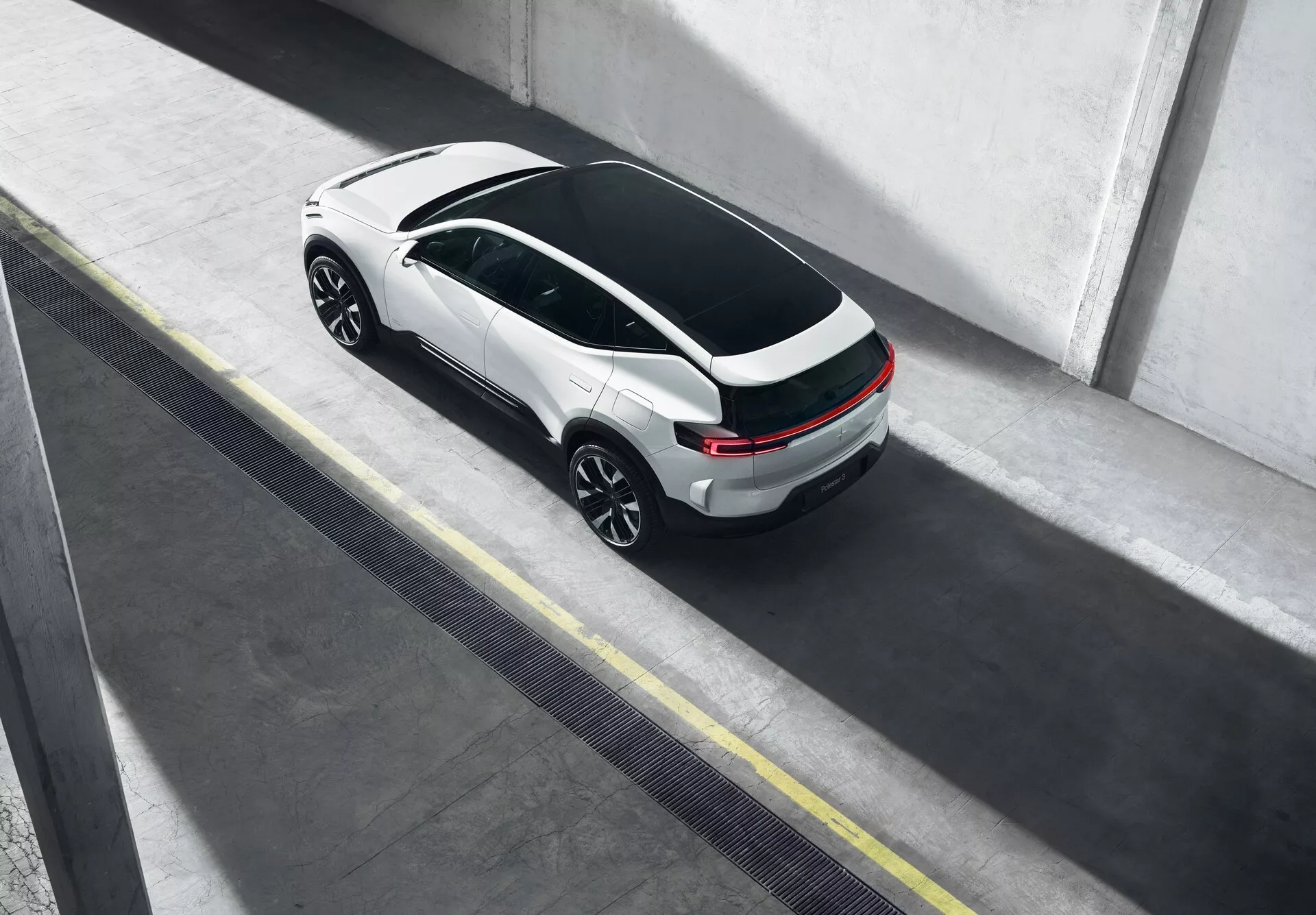 Polestar 3 Generazione 1 del 2023 visto dall'alto, parcheggiato in un contesto urbano con design distintivo del tetto panoramico e raffinata combinazione cromatica bicolore