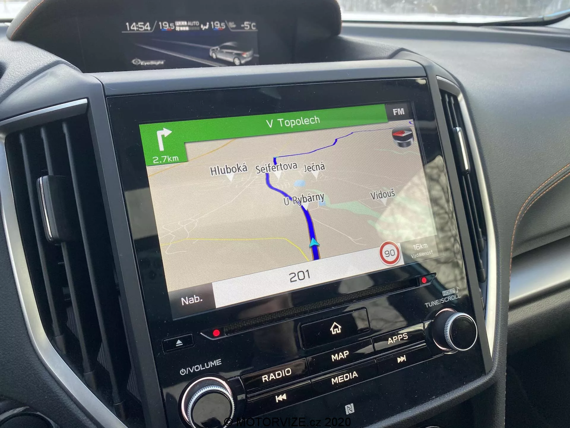 Consolle centrale della Subaru XV 2018 focalizzata sul sistema di infotainment che mostra una mappa di navigazione sullo schermo, con pulsanti per il volume, la radio, i media, le app e le impostazioni dell'auto, controlli aggiuntivi del clima parzialmente visibili, mostrando un percorso GPS, l'ora (14:54), la temperatura ambiente (-5,5°C), indicatori di connettività che suggeriscono funzionalità Bluetooth o Wi-Fi, evidenziando la moderna tecnologia automobilistica.