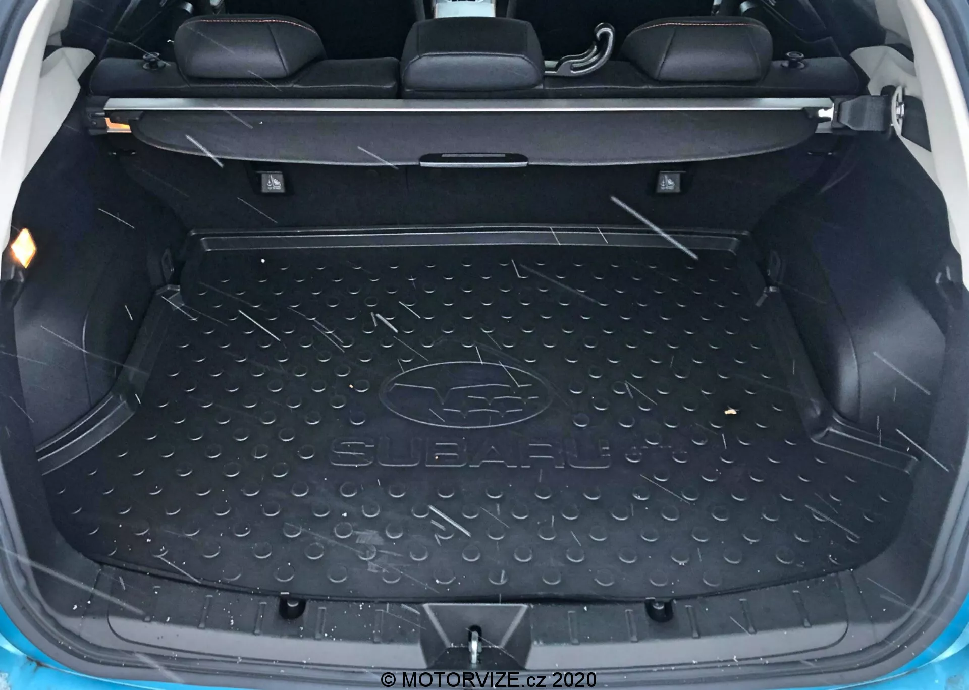 Vista interna del bagagliaio della Subaru XV 2018 che mostra un'area di carico spaziosa e vuota rivestita con un tappetino resistente e impermeabile con il logo Subaru, scomparti laterali modellati per riporre piccoli oggetti, schienali dei sedili posteriori visibili con poggiatesta che indicano che questo è un veicolo a 5 posti, meccanismo di piegatura dei sedili posteriori, punti di ancoraggio e ganci per fissare il carico e illuminazione interna per la visibilità.