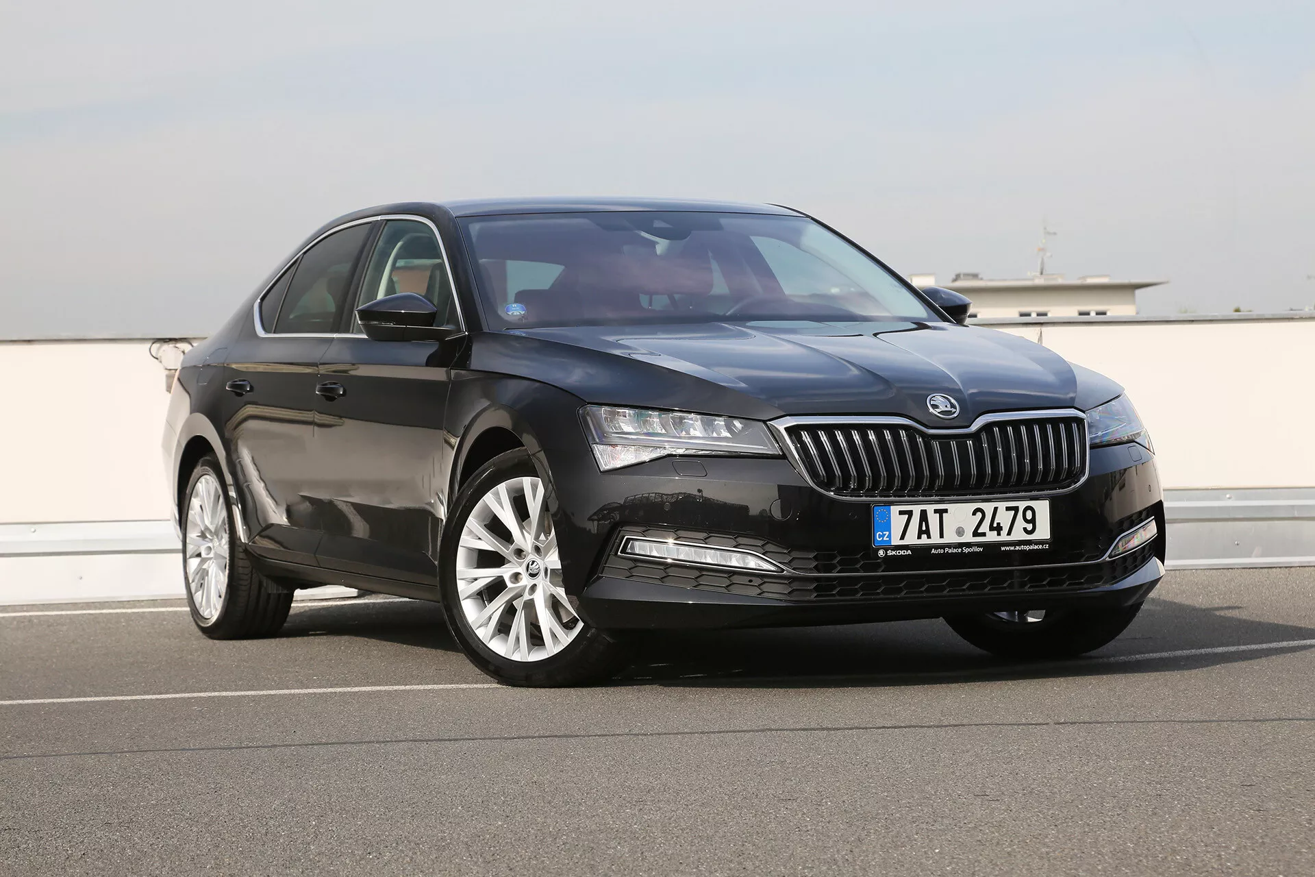 Toyota Camry Limousine 2019 ferma su una strada aperta con griglia elegante a lamelle verticali, fari LED moderni e cerchi in lega a più razze, mostra il suo design elegante e sportivo da un angolo anteriore di tre quarti