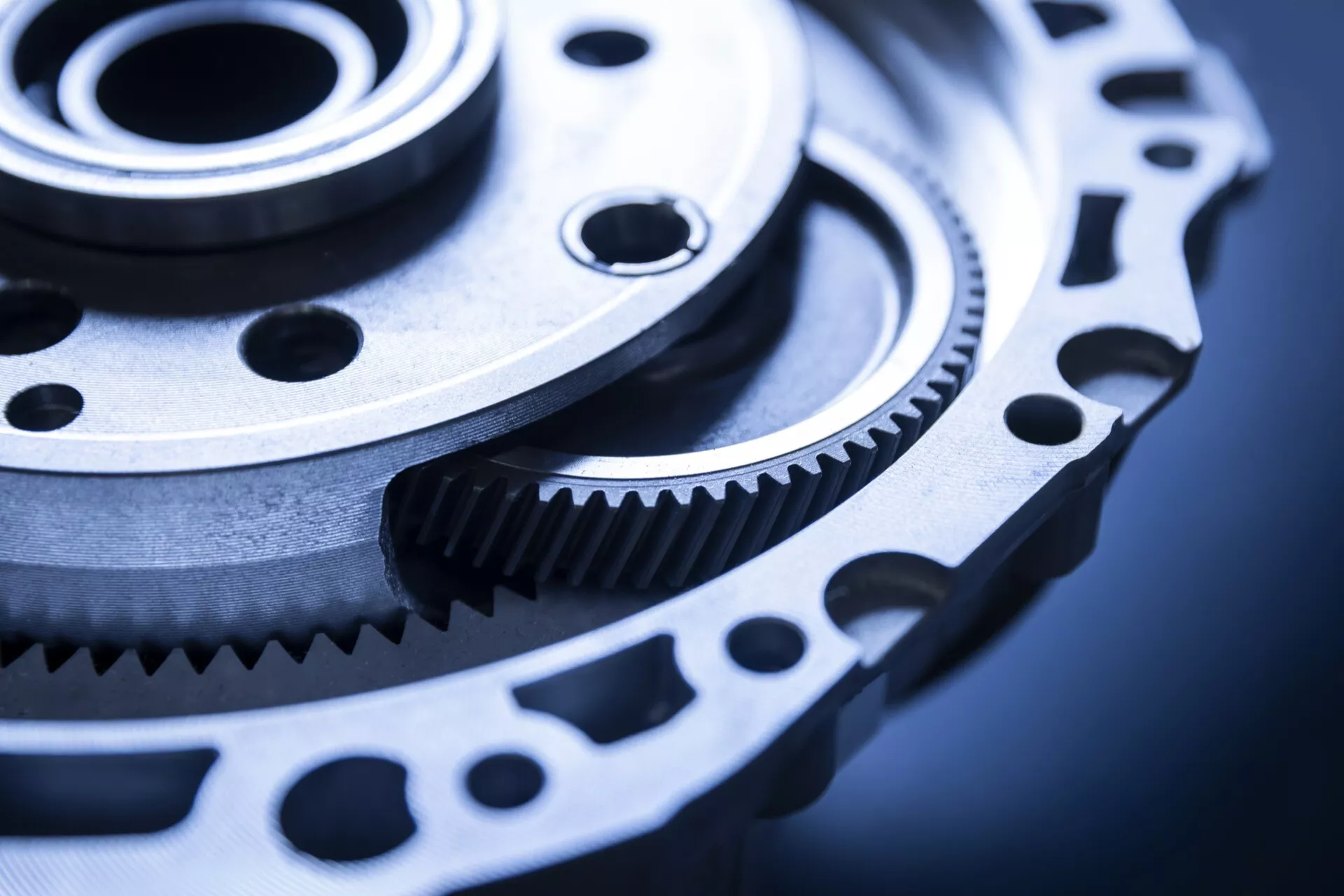 Inquadratura ravvicinata di ingranaggio e ruota dentata ad alta precisione ingegneristica, probabilmente per uso automobilistico, che mostra una lavorazione fine e potenziale per la trasmissione di potenza in un contesto industriale freddo