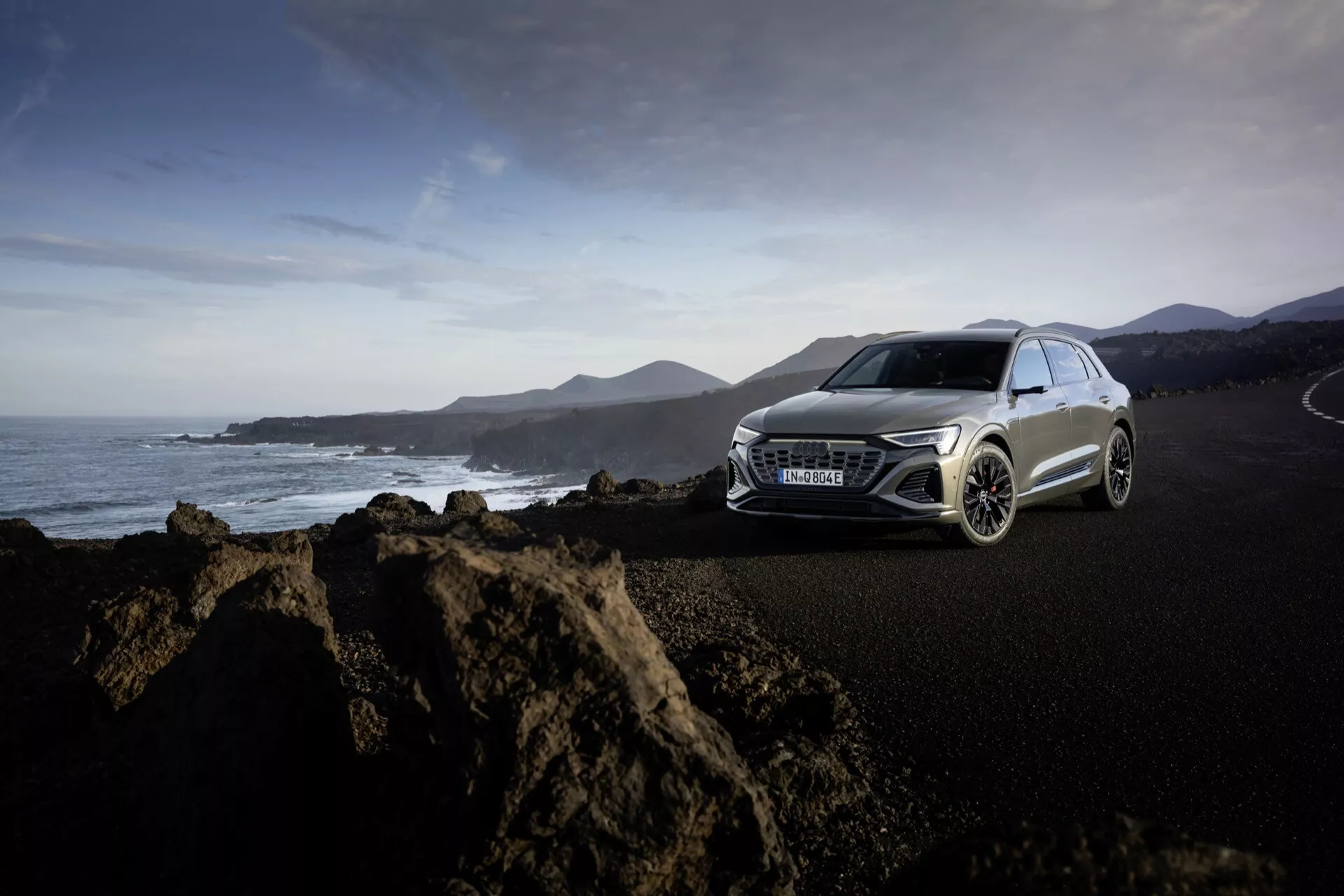 Vista frontale laterale dell'Audi Q8 E-Tron GE 2023 in blu metallico sull'autostrada