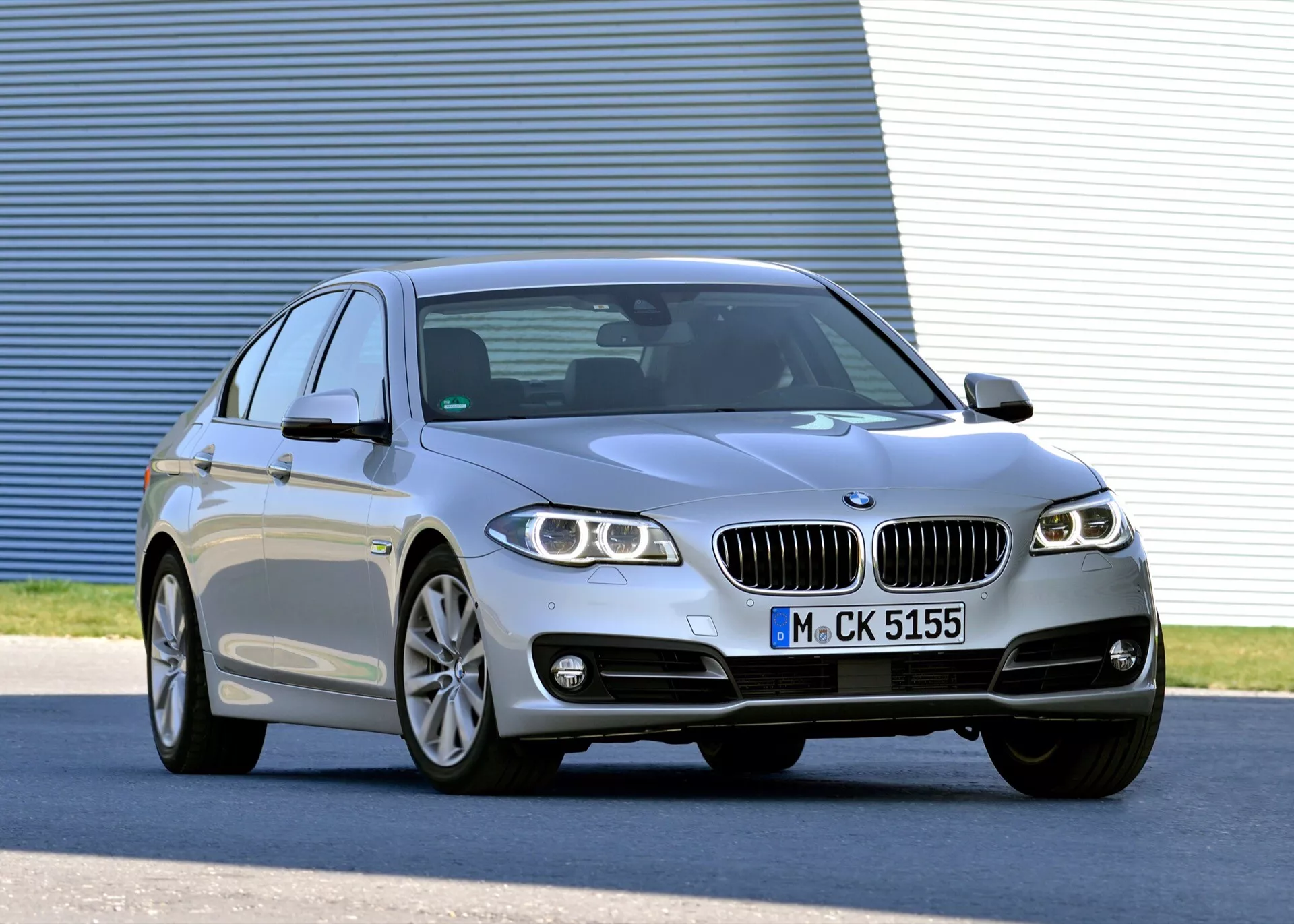 Berlina di lusso argento BMW Serie 5 (F07-F10-F10M-F11-Facelift) del 2013 in vista frontale tre quarti che mostra fari LED, ruote in lega, griglia frontale a doppio rene, carrozzeria sportiva a quattro porte con tetto a coupé e caratteristiche tecnologiche avanzate
