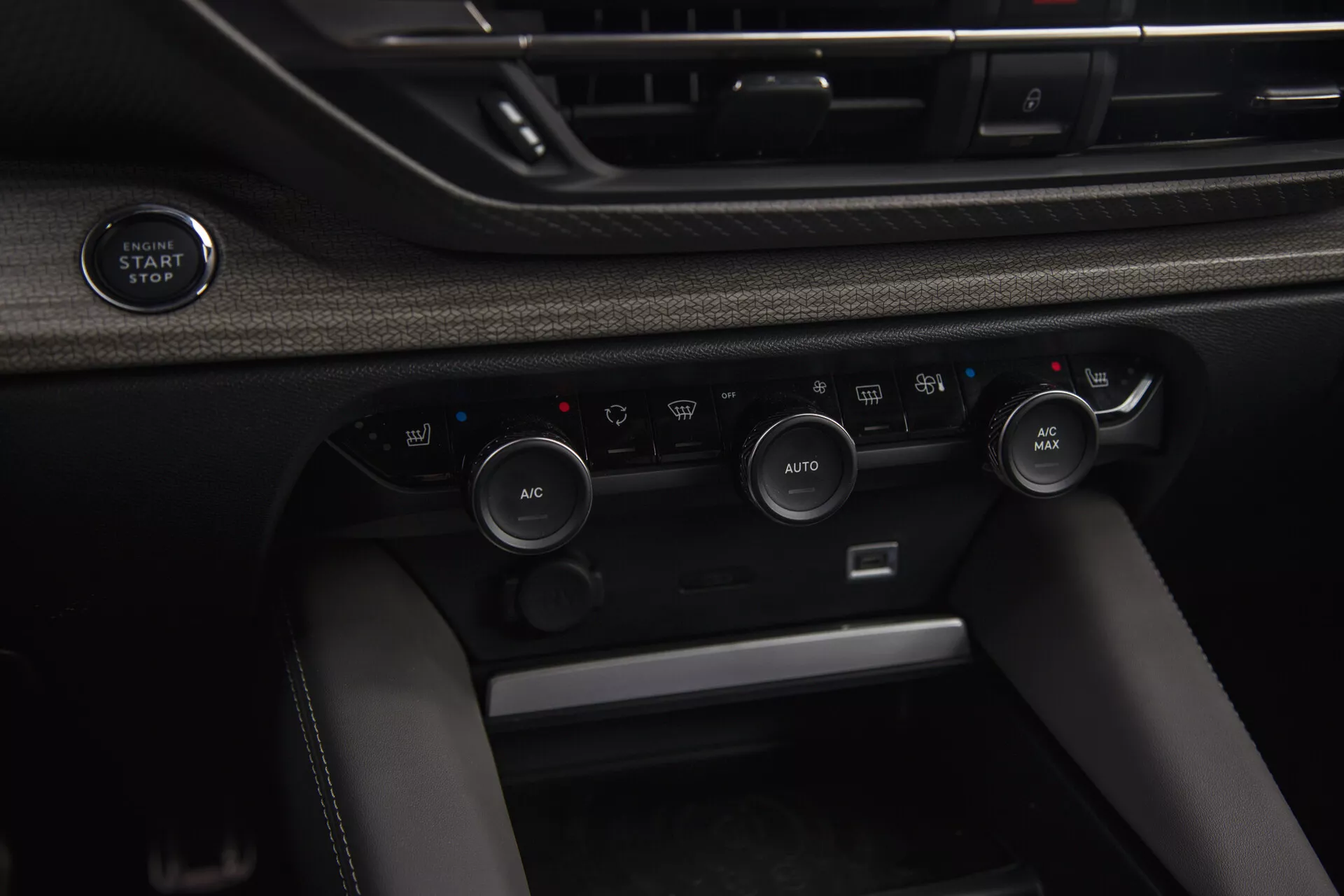Vista ravvicinata dell'interno della Citroen C5-X 2022 con pulsante di avvio/arresto senza chiave e sistema di controllo climatico avanzato con regolazione automatica della temperatura e opzioni di ricircolo dell'aria.
