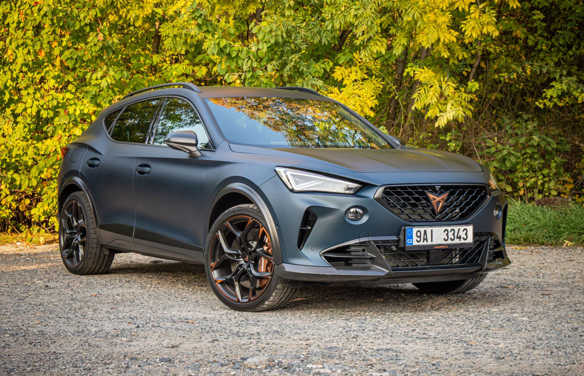 SUV crossover Cupra Formentor 2020 parcheggiato all'aperto, mostrando prospettiva frontale di tre quarti con enfasi sul design sportivo, facciata anteriore con fari LED e griglia, profilo laterale con ruote in lega a più razze e potenziale capacità fuoristrada