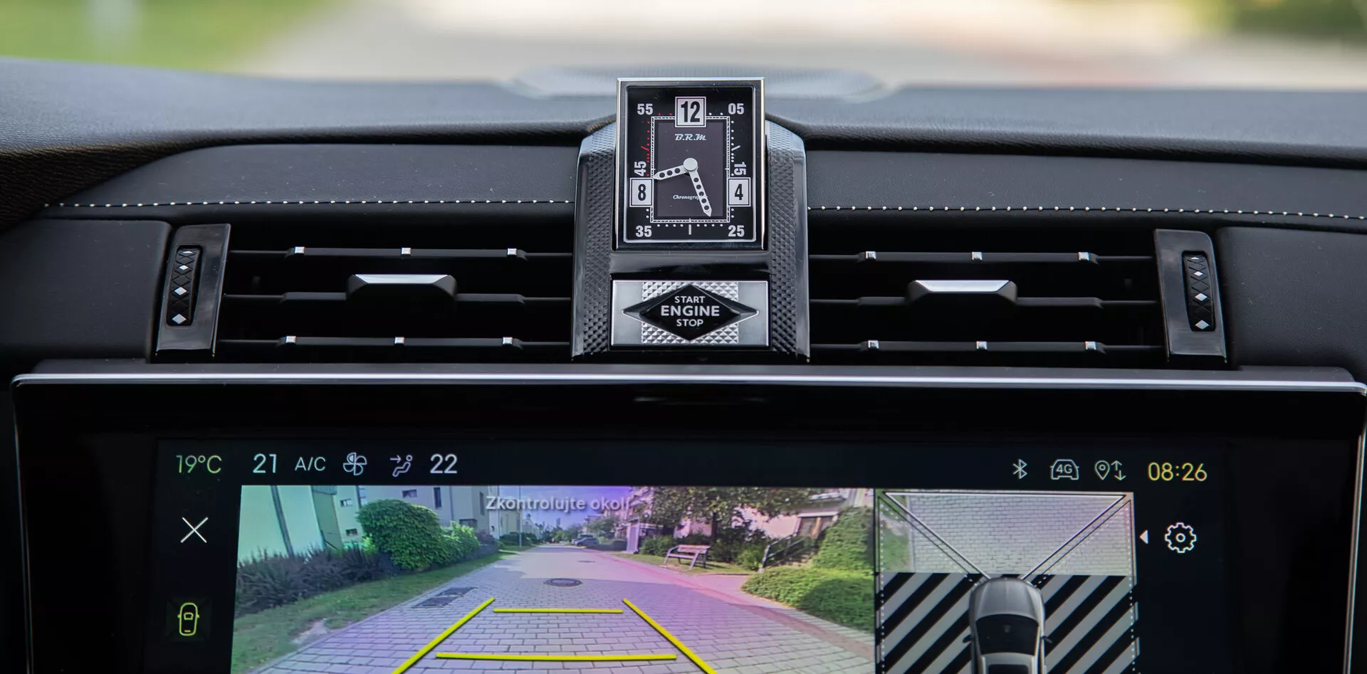 Vista interna della DS Automobiles DS-7 2022 con cruscotto, orologio analogico di lusso e display del sistema di infotainment centrale con telecamera posteriore e funzione di assistenza al parcheggio