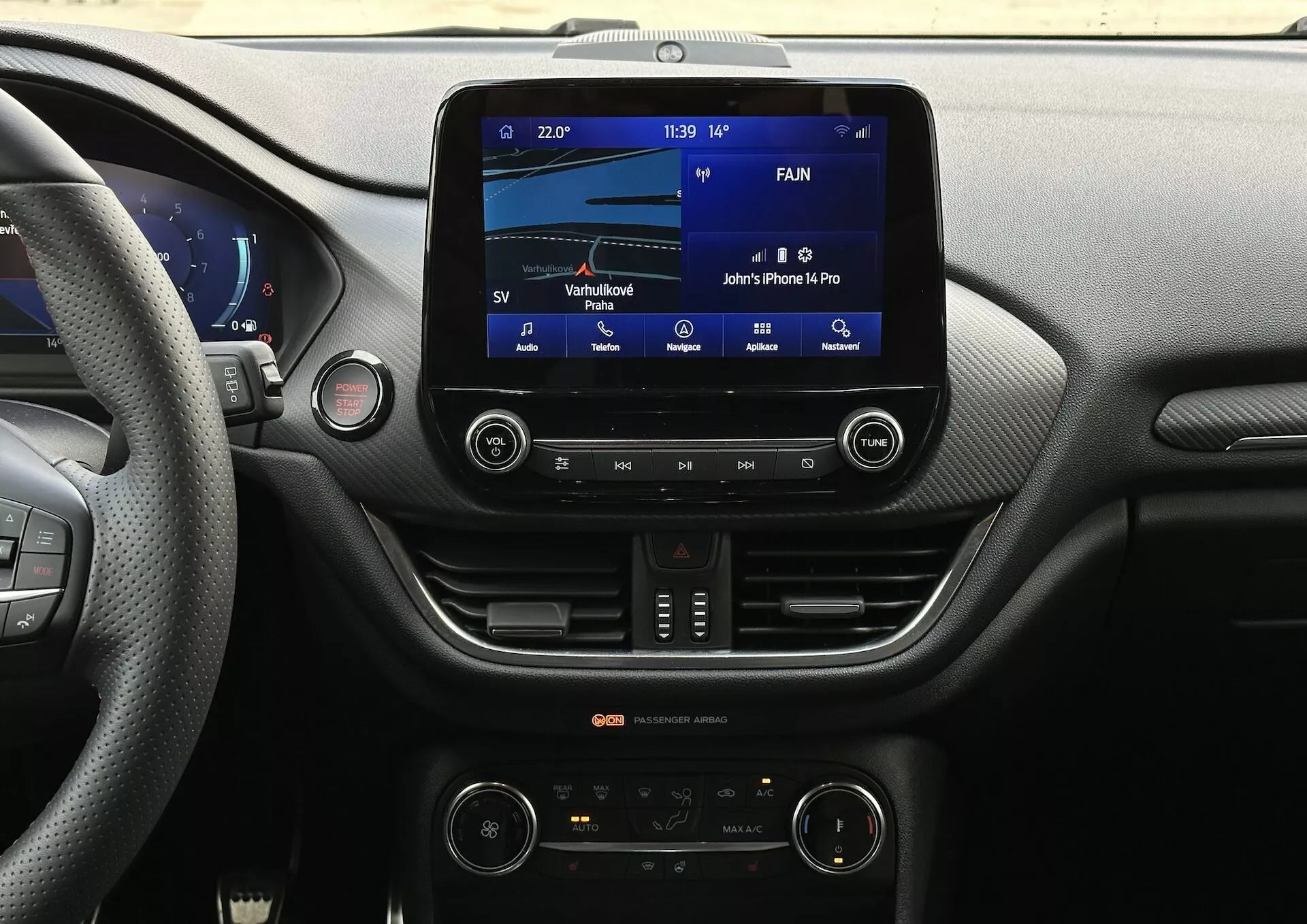 Vista del cruscotto interno della Ford Fiesta 2022 dal sedile del conducente con focus sul sistema di infotainment e sulle funzionalità della console centrale, inclusi display touch screen, connettività Bluetooth e controllo climatico bizona