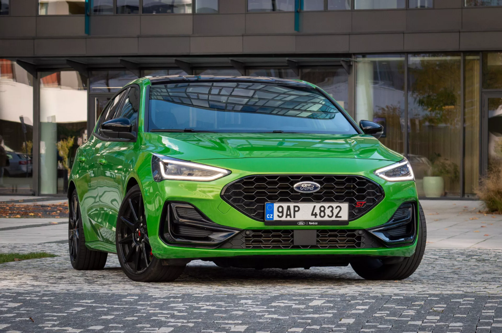 Ford Focus ST 2022 in verde vibrante da una prospettiva frontale di tre quarti evidenziando la griglia, i fari LED, il paraurti sportivo, le linee del cofano e la ruota in lega a più razze