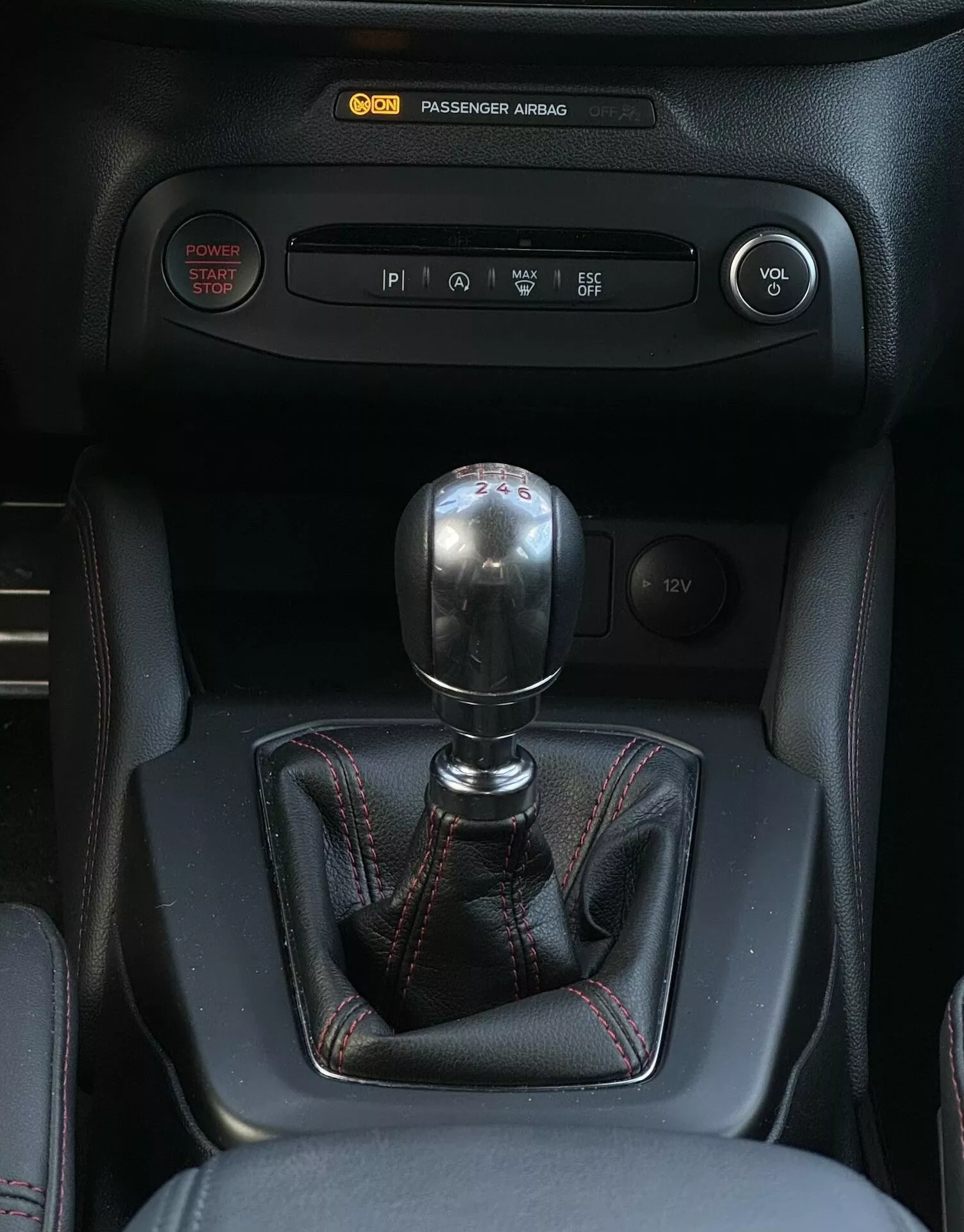 Vista ravvicinata dell'interno della Ford Focus ST 2022 che mostra il cambio manuale con disposizione a 6 velocità, pulsante di avviamento senza chiave, controllo del clima e comandi dell'infotainment.