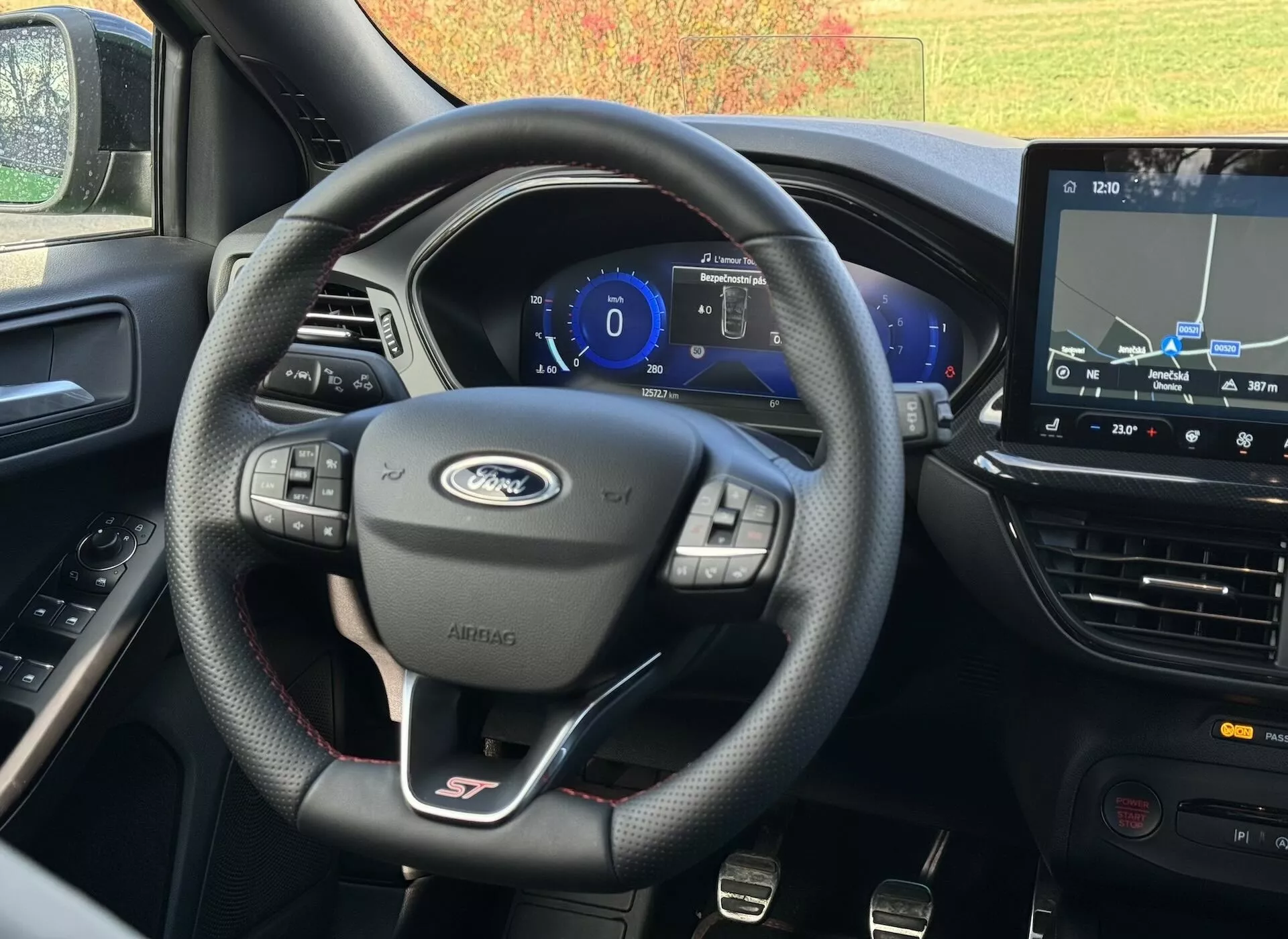Vista interna del Ford Focus ST 2022 dal sedile del conducente che mostra il volante in pelle con badge ST, quadro strumenti digitale e sistema di navigazione touchscreen