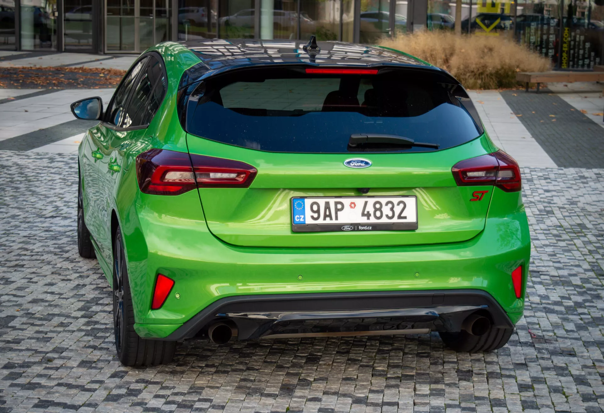 Ford Focus ST 2022 in verde brillante, che mostra il suo angolo posteriore sportivo con doppio scarico, spoiler posteriore e luci posteriori LED