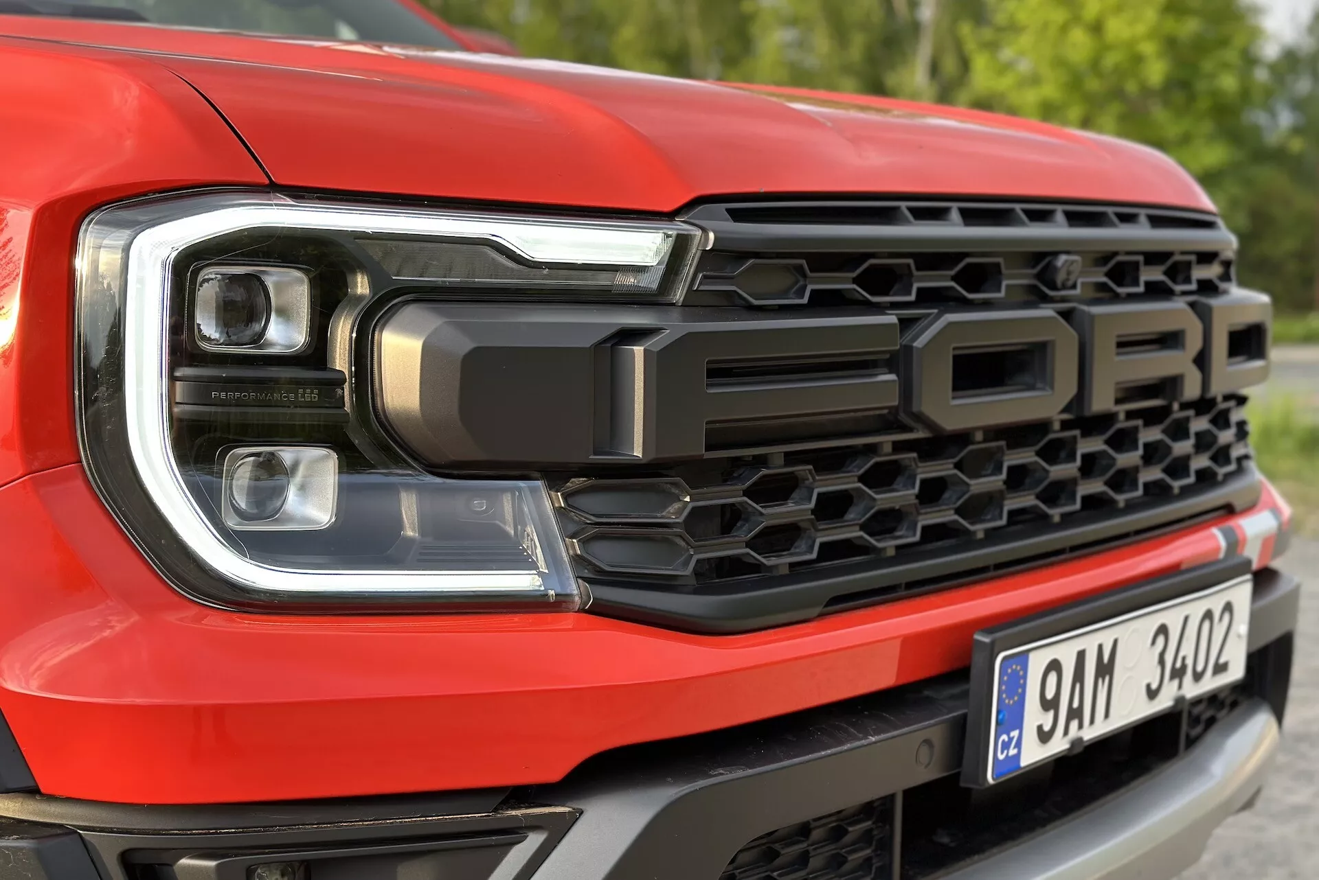 Primo piano del lato anteriore sinistro della Ford Ranger 2022 che mette in evidenza il design dei fari LED e il modello a griglia a nido d'ape, con la scritta 'FORD'