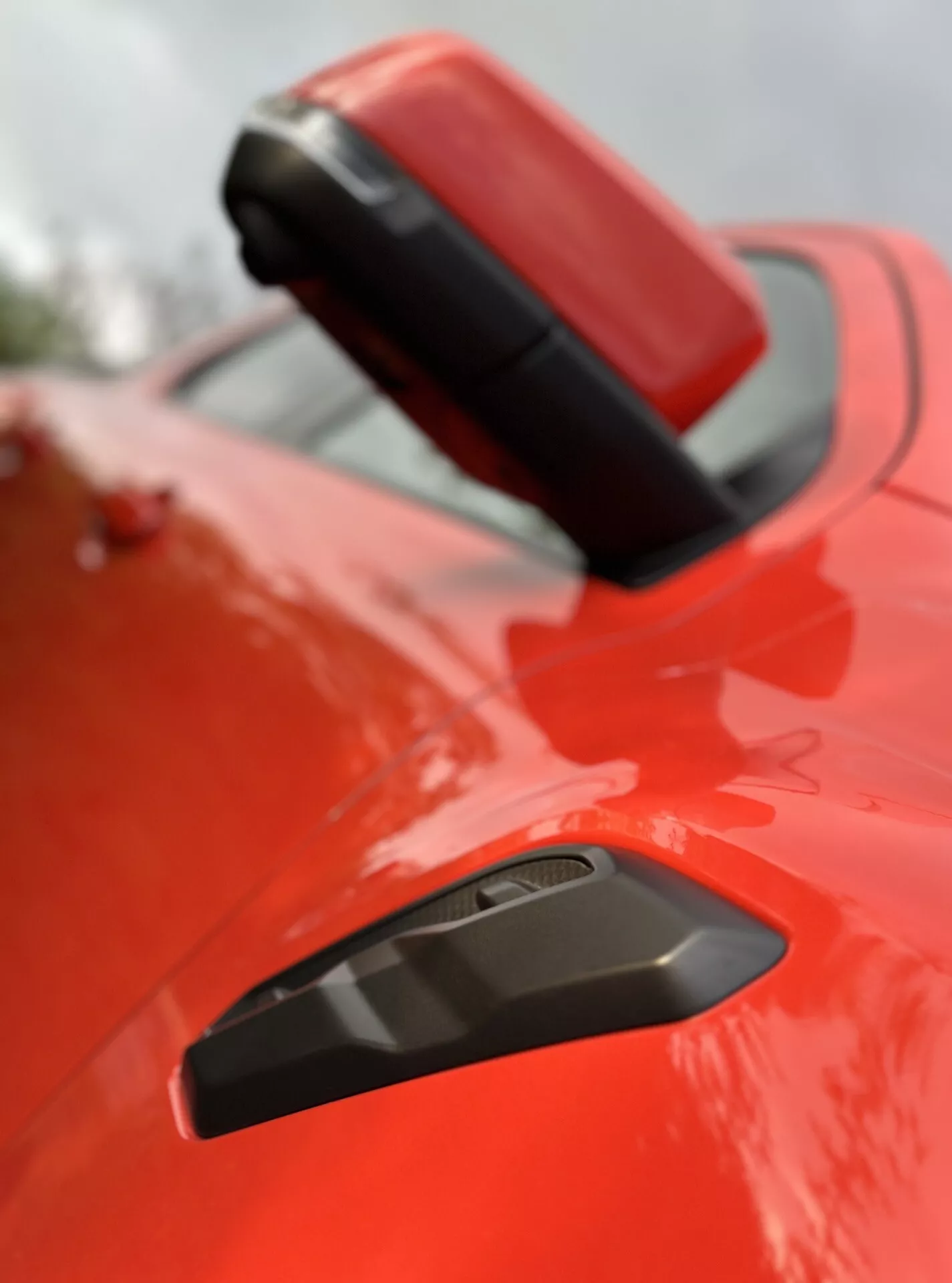 Primo piano del parafango posteriore e spoiler del Ford Ranger 2022 con finitura rossa brillante, con griglia nera per migliorare l'aerodinamica, sottolineando il suo design sportivo sotto una profondità di campo ridotta