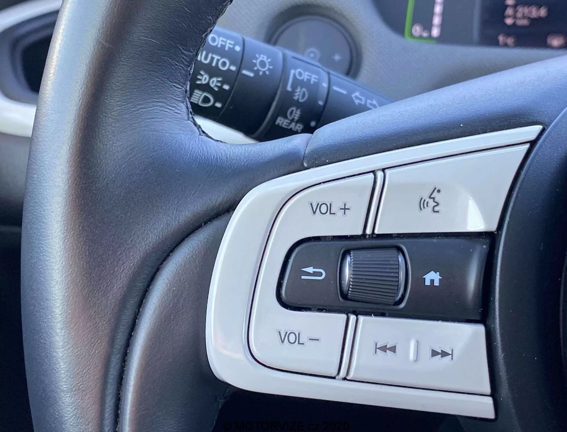 Vista ravvicinata dei comandi montati sul volante della Honda Jazz Crosstar 2020, mostrando la regolazione del volume, il sistema telefonico con vivavoce e i pulsanti per il possibile controllo della velocità o la selezione delle tracce audio. Messa a fuoco centrale sul volante rivestito in pelle con rifiniture argento che enfatizzano il comfort e il design elegante.