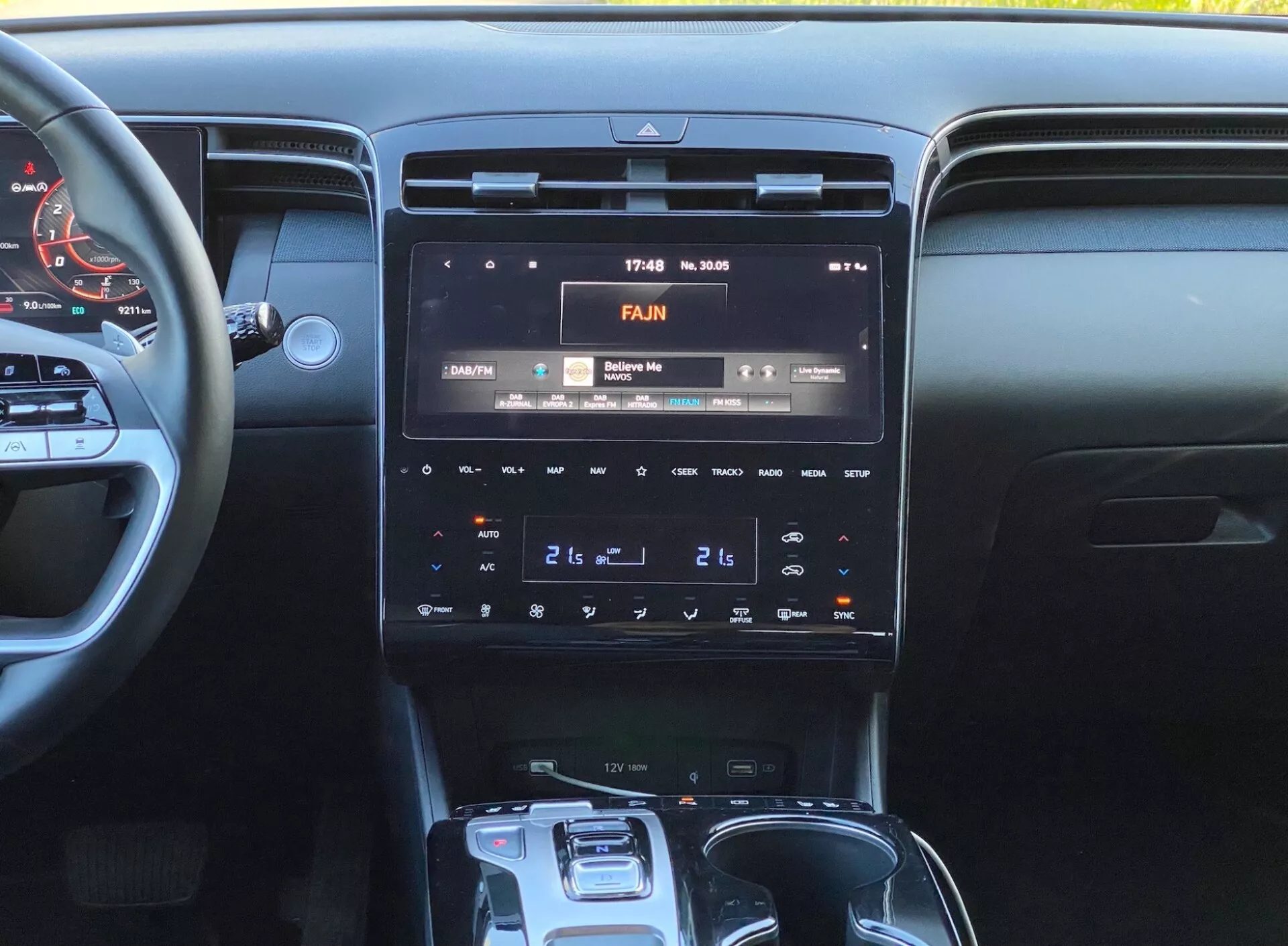 Immagine degli interni della Hyundai Tucson 2020, con particolare attenzione alla console centrale con schermo di infotainment ad alta risoluzione che mostra le 17:43 e 30°C, pannello del controllo climatico a due zone, e selettore del cambio automatico.