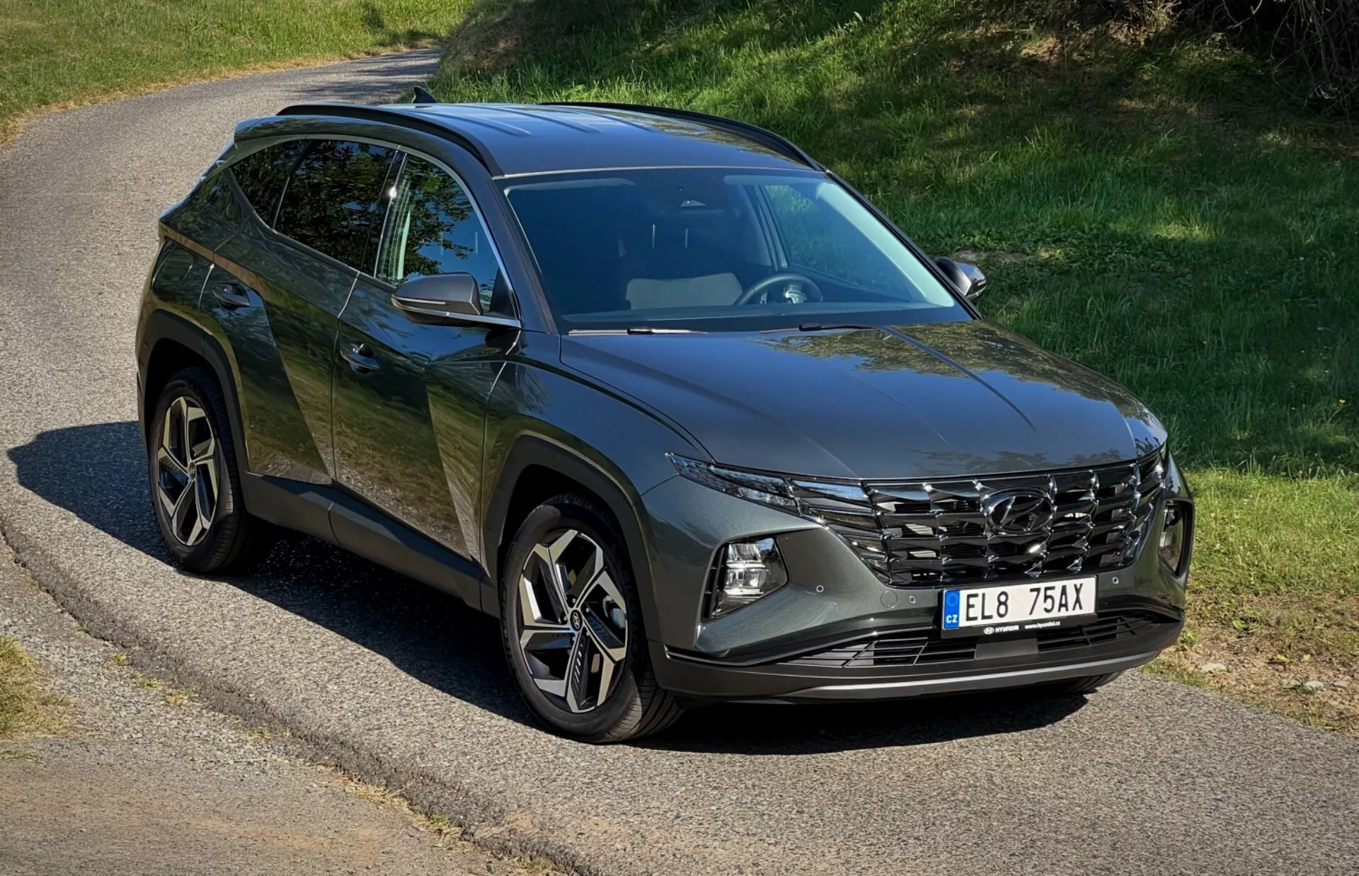 SUV Hyundai Tucson 2020 parcheggiata su una strada isolata che mostra la sua griglia anteriore, fari LED, cerchi in lega e linee del corpo sotto la luce naturale del sole
