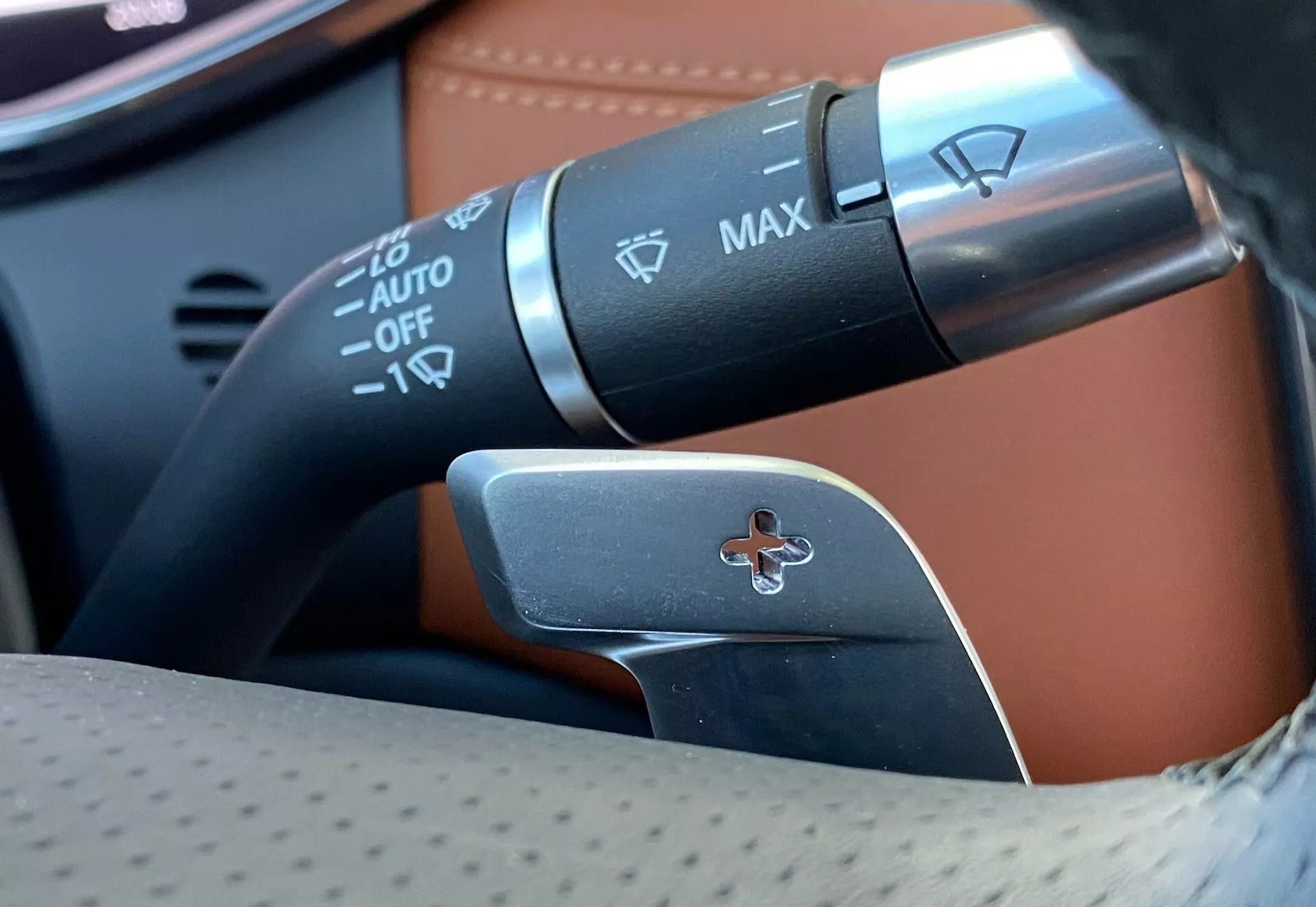 Vista ravvicinata della colonna di sterzo della Jaguar XF 2021 che mostra le leve di controllo; include la leva degli indicatori di direzione e il controllo dei fari con fari automatici, controllo dei fendinebbia e leva per la selezione manuale delle marce.