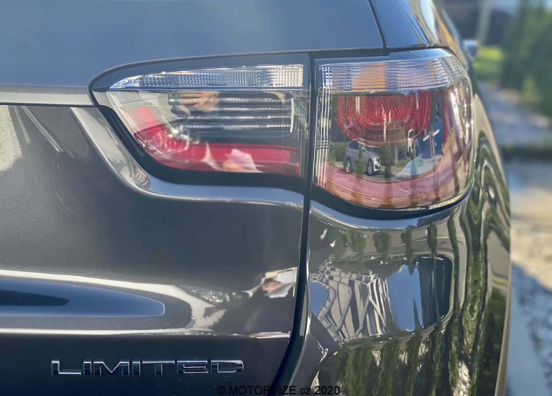 Una ripresa ravvicinata e angolata del lato posteriore sinistro di una Jeep Compass 2017, con il gruppo di fanali posteriori con luce di stop rossa e sezioni chiare, che mostra chiaramente il badge 'LIMITED' della versione. Sono visibili la finitura metallica e gli angoli affilati del design con tecnologia di illuminazione a LED, scattata in una giornata di sole.