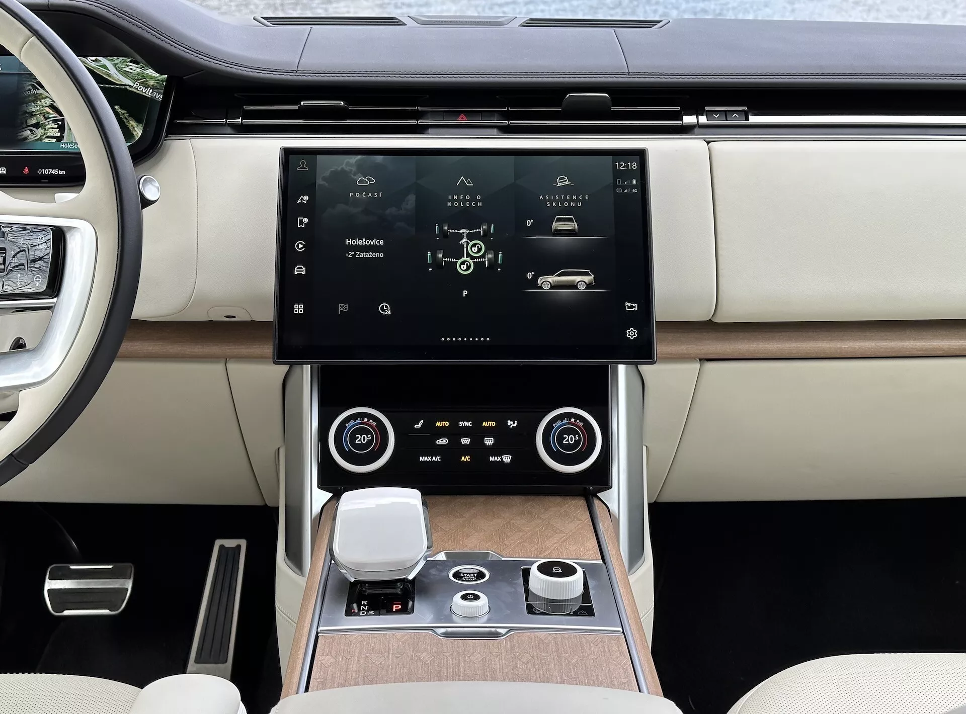 Land Rover Range Rover 2021 con interni moderni, focalizzati sulla console centrale e sul sistema di infotainment con schermo touchscreen ad alta risoluzione, bocchette dell'aria con dettagli cromati, controllo della climatizzazione a doppia zona, manopola di controllo rotativa per la navigazione del sistema e sedili lussuosi in pelle bicolore con dettagli in finitura legno.