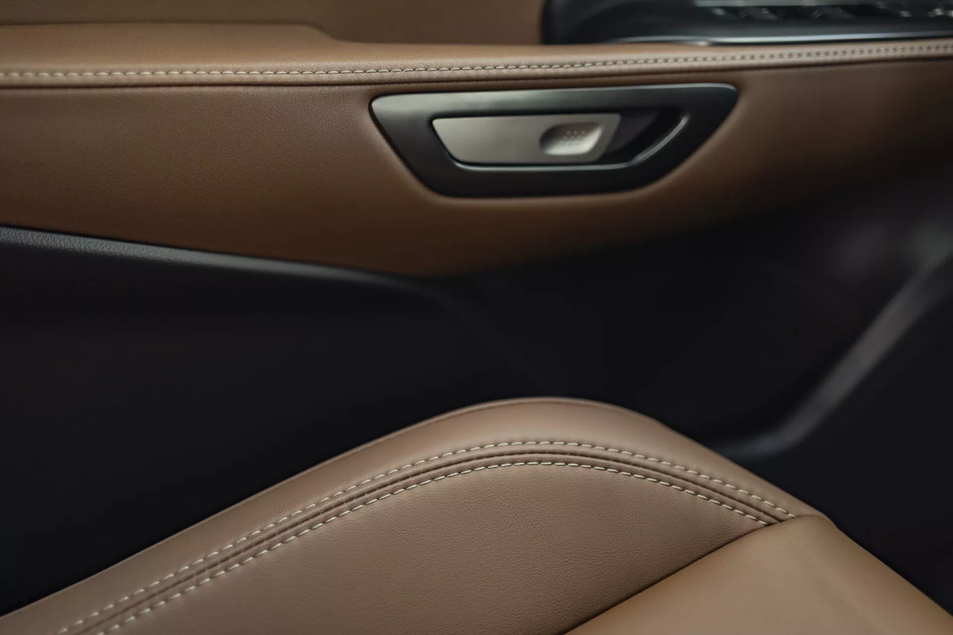 Vista dettagliata dell'interno della Lexus LBX 2024 che mostra un lussuoso rivestimento della porta in pelle marrone, design del sedile ergonomico e funzionalità di illuminazione ambientale