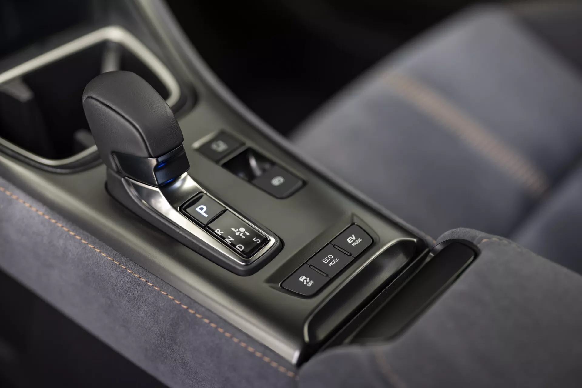 Zona leva cambio automatica Lexus LBX 2024 1ª generazione nella console centrale con indicatore posizione parcheggio, circondata da pannello lucido con pulsanti e bordo argento, con dettagli in pelle