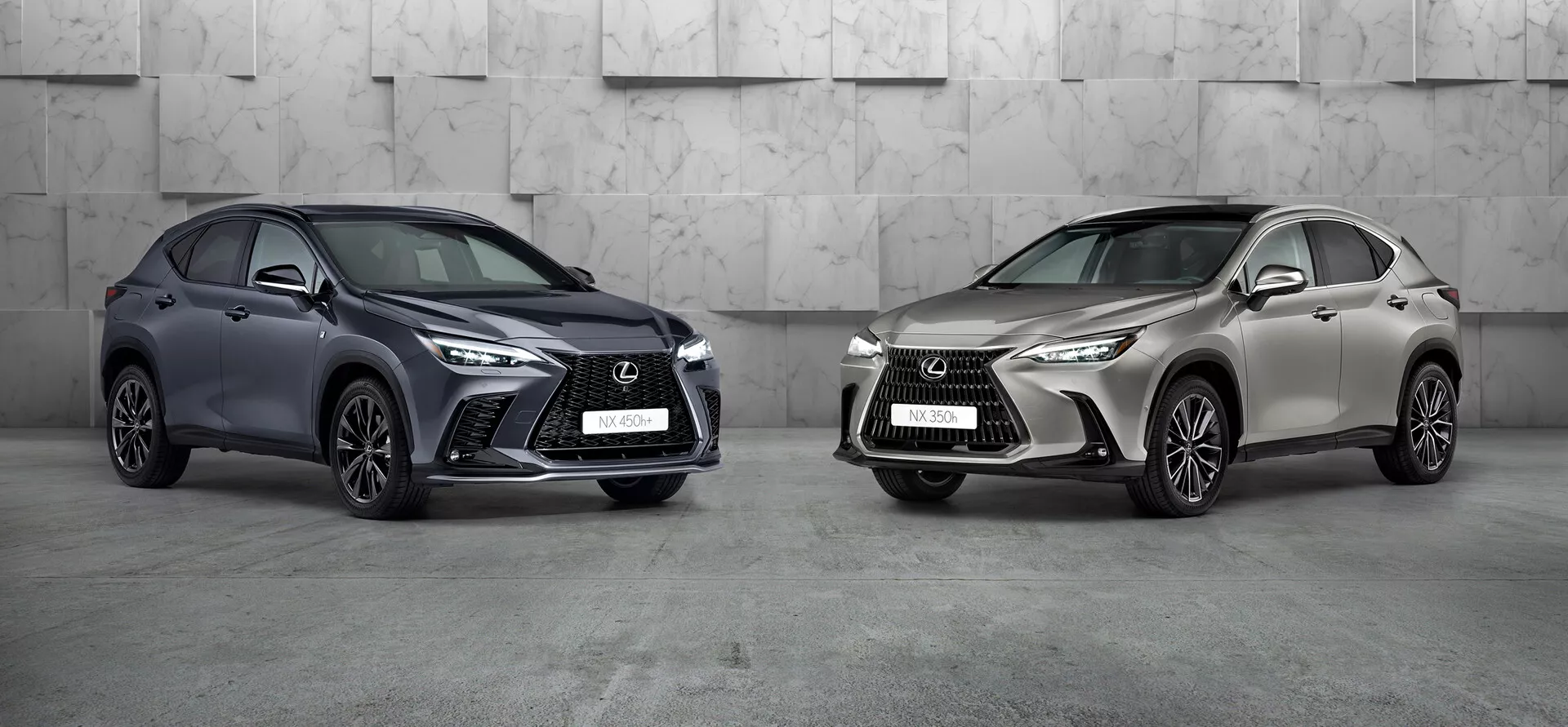 L'immagine presenta due Lexus NX 2021 in un ambiente studio professionale. L'auto a sinistra, un SUV compatto di colore scuro con una distintiva griglia frontale aggressiva, fari LED affilati e grandi prese d'aria, è angolato per mostrare la parte anteriore sinistra e il lato. Le ruote sono girate verso la fotocamera, evidenziando il design delle cerchioni. L'auto a destra, di colore metallizzato chiaro, è anch'essa inclinata ma verso sinistra, condividendo un linguaggio di design simile con uno stile di cerchione differente. Entrambi i SUV di lusso, posizionati prominente nell'inquadratura, mostrano un design avanzato e possibili tecnologie moderne.