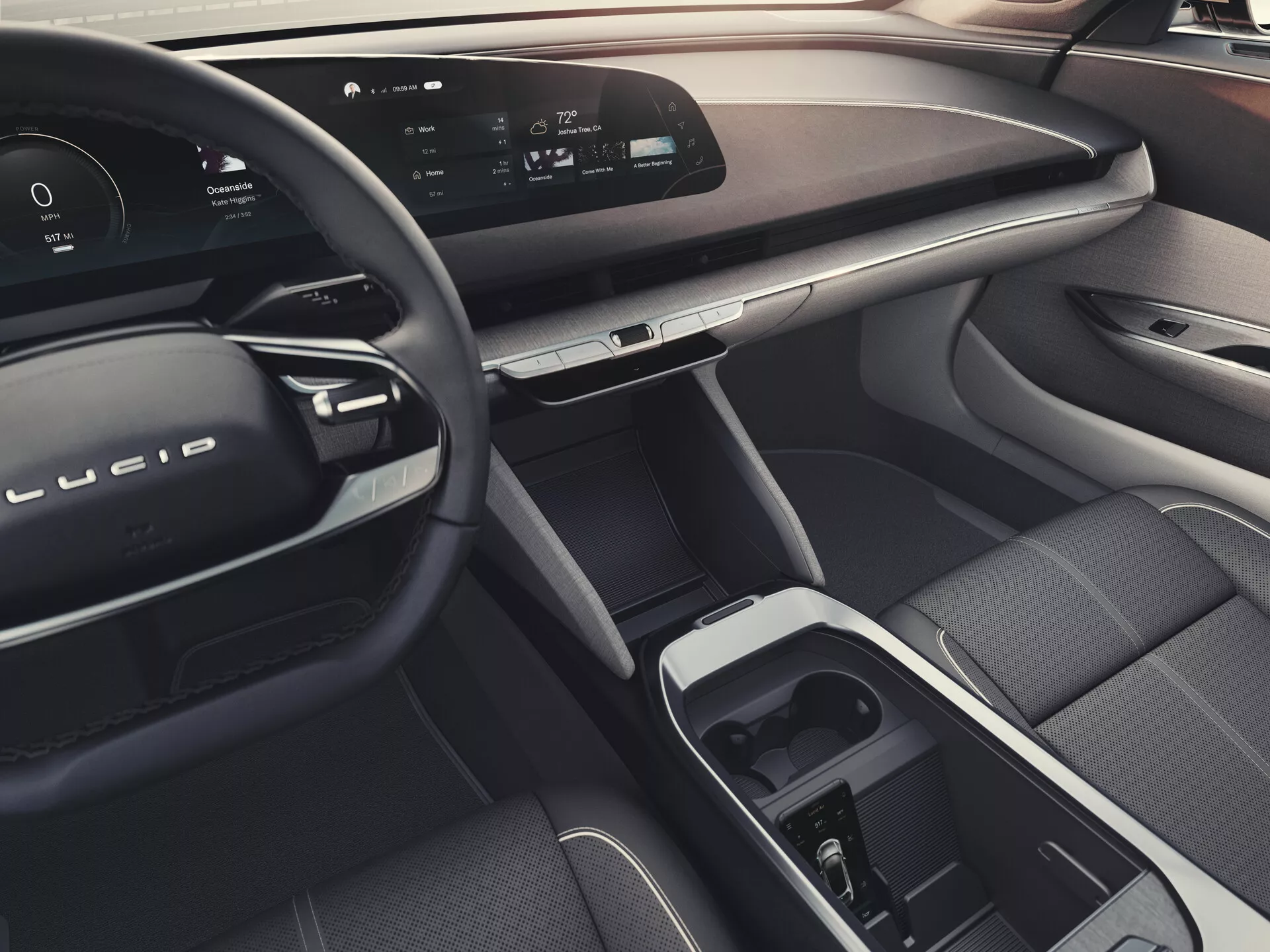Vista interna della Lucid Air 2022 (1ª generazione) dal sedile posteriore, che mostra una plancia elegante con display digitale continuo, volante moderno con controlli integrati, materiali di lusso, touchscreen centrale e selettore del cambio nella console centrale, sedile anteriore ergonomico per il passeggero, controlli avanzati per i finestrini e gli specchietti sulla portiera del passeggero, atmosfera generale indicativa di funzionalità di illuminazione ambientale.
