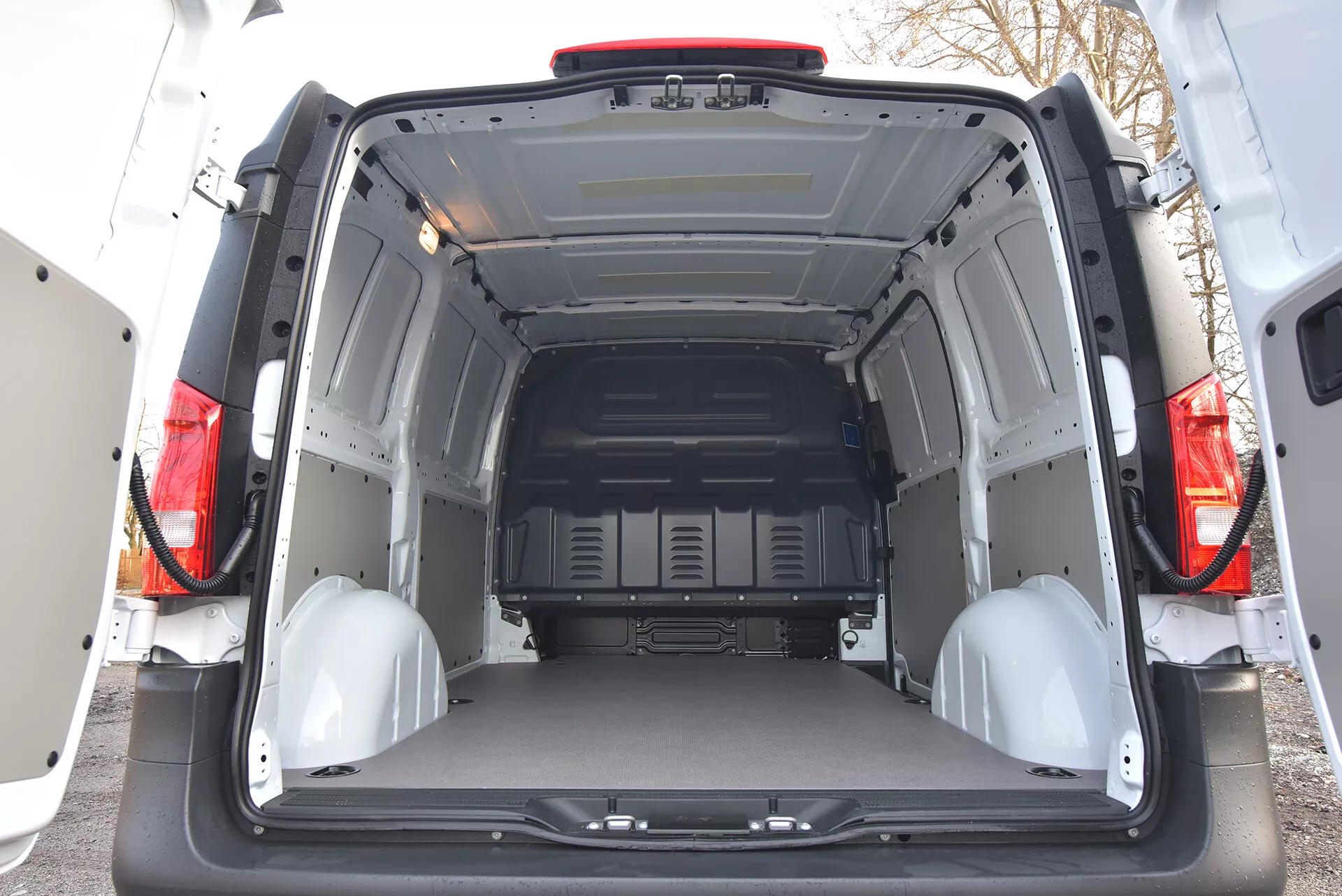 Vista interna posteriore di un Mercedes-Benz Vito Tourer 2014 che mostra un'area di carico spaziosa e vuota con porte aperte, pannelli protettivi e punti di ancoraggio