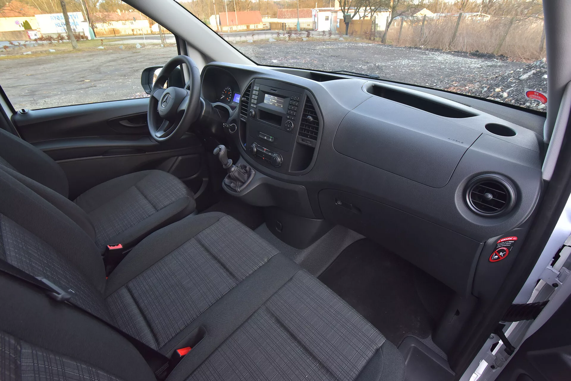 Vista interna del Mercedes-Benz Vito Tourer del 2014 dal lato del guidatore che mostra il cruscotto anteriore, la trasmissione manuale, pannelli di controllo e sedili in tessuto