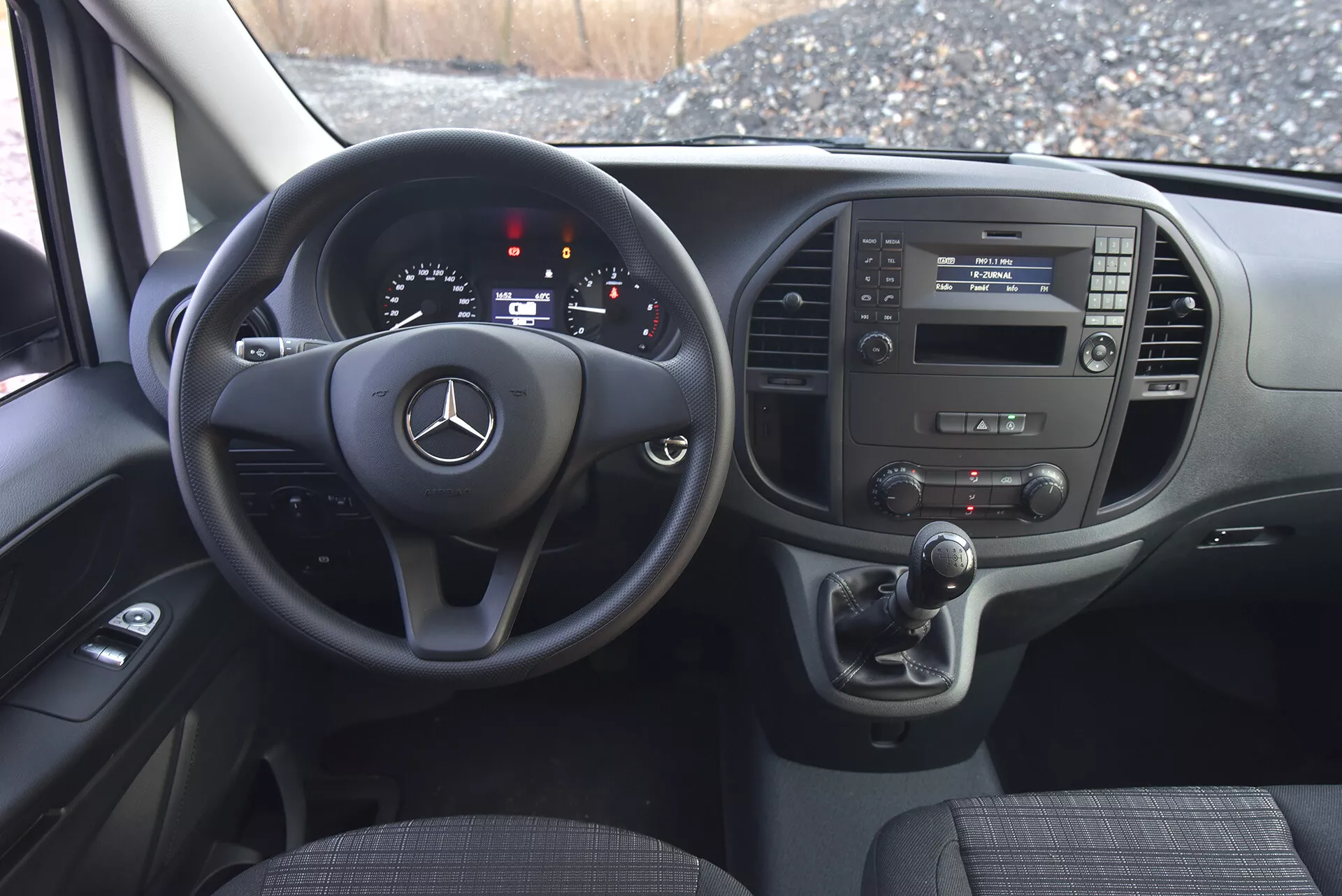 Vista interna del Mercedes-Benz Vito 2014 (Vito-Tourer) con focus sull'area del guidatore che mostra dettagliatamente il volante, il quadro strumenti e la console centrale con pulsanti multifunzione, indicatori analogici e digitali e sistema di controllo del clima