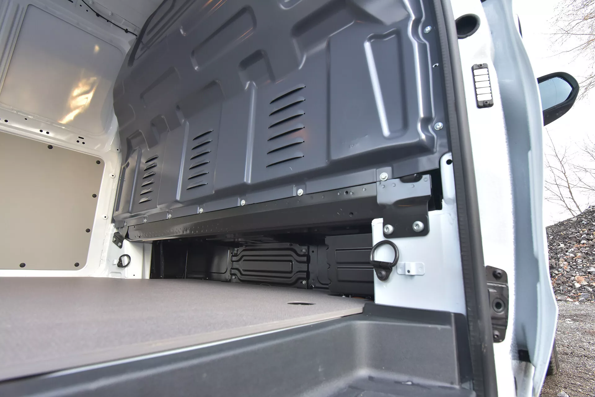 Vista interna posteriore di un furgone commerciale Mercedes-Benz Vito Tourer del 2014, evidenziando l'ampia area di carico a pavimento piatto con porte aperte e superfici durevoli per un caricamento efficiente e un trasporto sicuro.