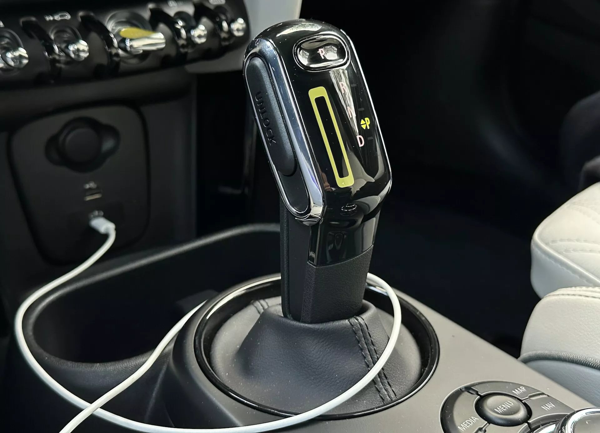 Vista ravvicinata della leva del cambio automatico con modalità di cambio manuale e indicatore LED della marcia all'interno dell'abitacolo della Mini Electric 2021