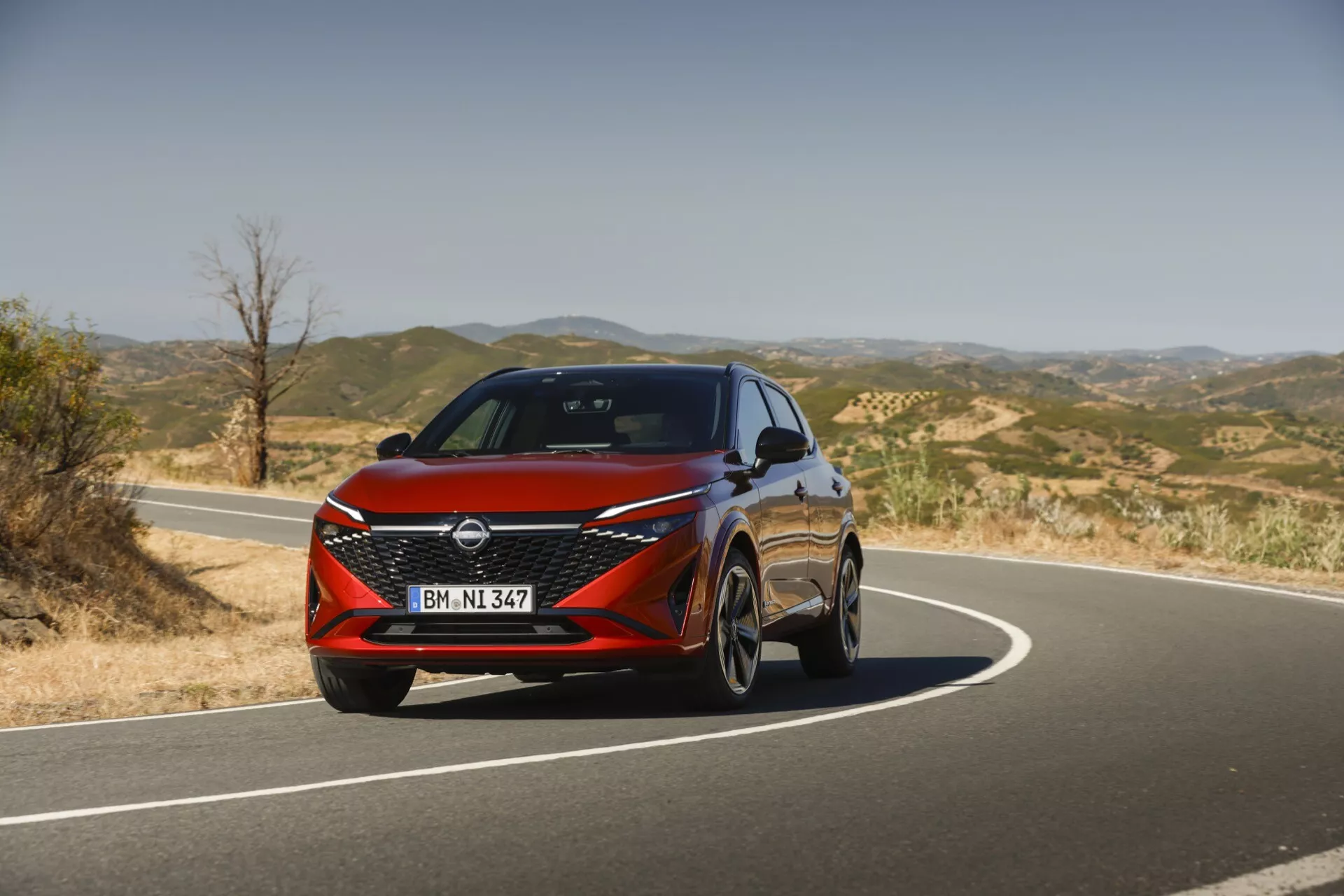 Vista frontale del Nissan Qashqai 2024 J12-facelift che mostra il suo design moderno con fari LED eleganti, un'audace griglia anteriore a V-motion e linee dinamiche che enfatizzano la sua estetica sportiva e sofisticata.