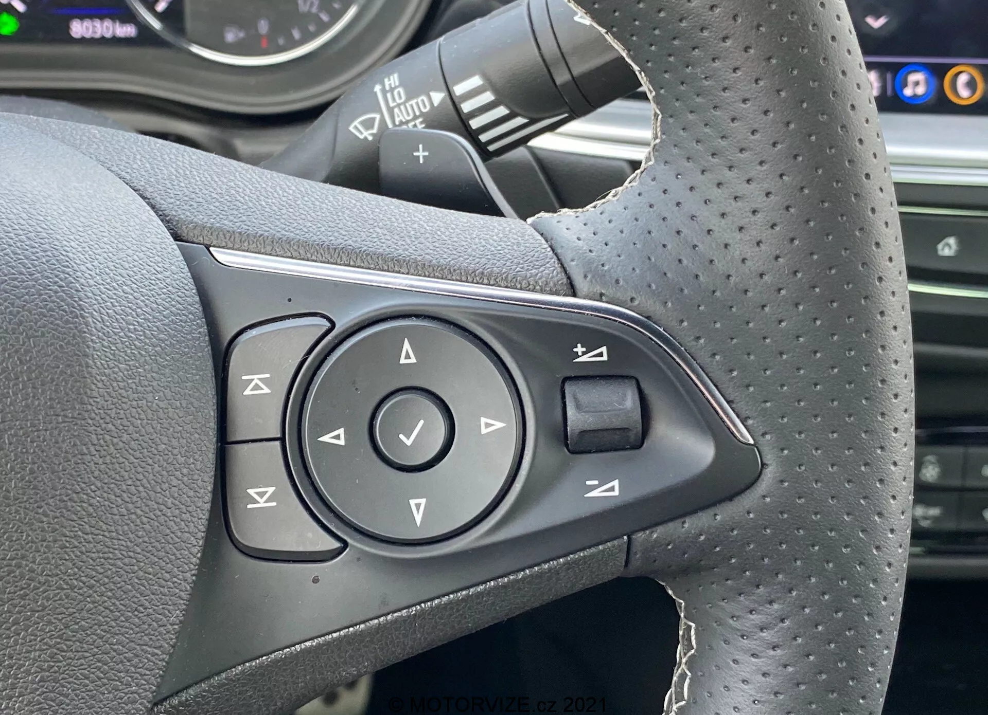 Vista laterale di una Opel Insignia GSi Grand Sport 2020 in movimento, che mostra il suo elegante design aerodinamico, i sofisticati fari a LED e i cerchi in lega sportivi