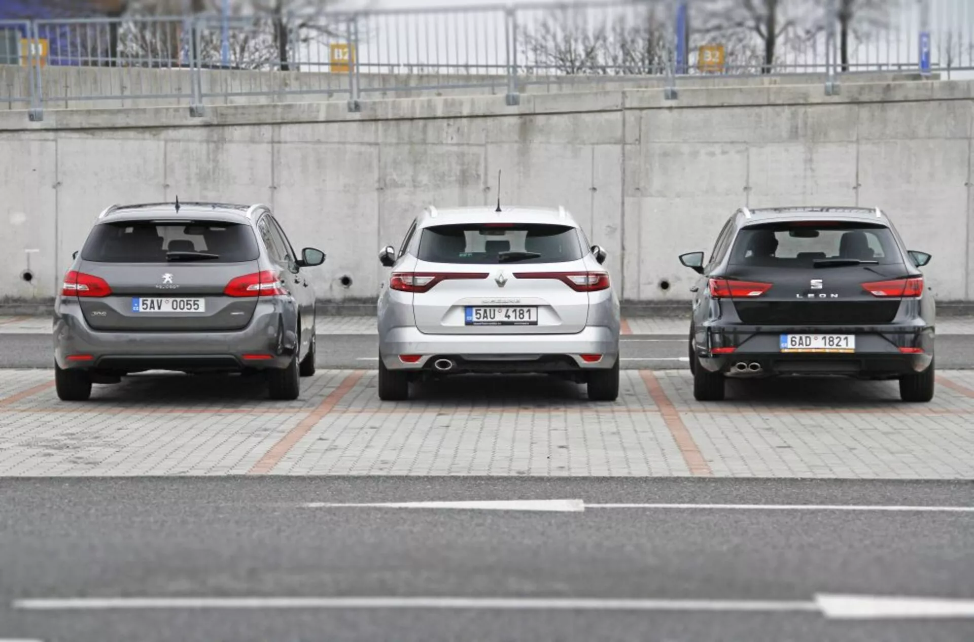 Tre auto Peugeot 308 SW 2013 parcheggiate una accanto all'altra mostrando il design posteriore incluso i fanali posteriori, i paraurti e le targhe in un contesto di parcheggio urbano