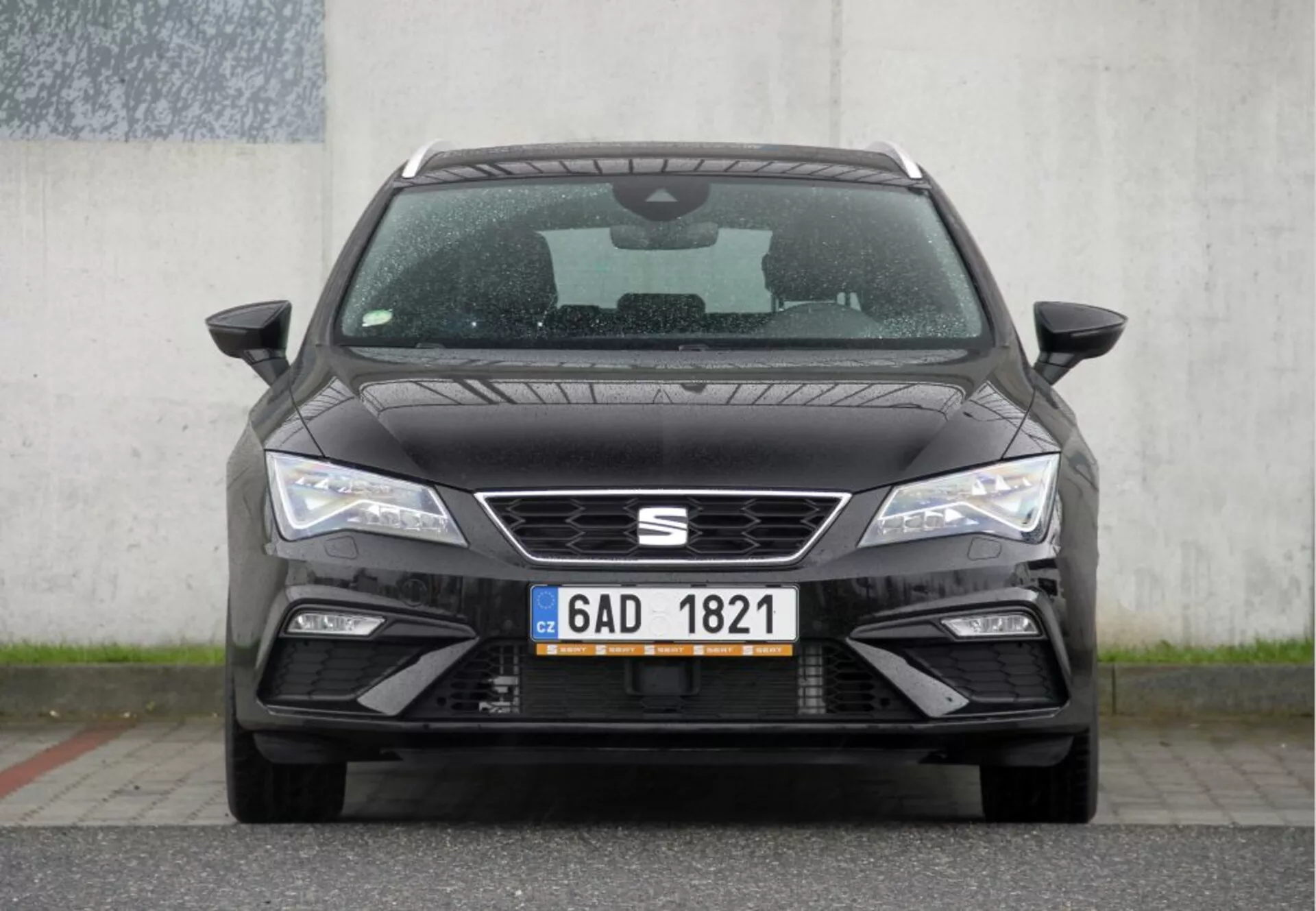 Vista frontale di una Peugeot 308 SW del 2013 che mostra la distintiva griglia anteriore, fari LED aguzzi e il paraurti anteriore elegante con prese d'aria