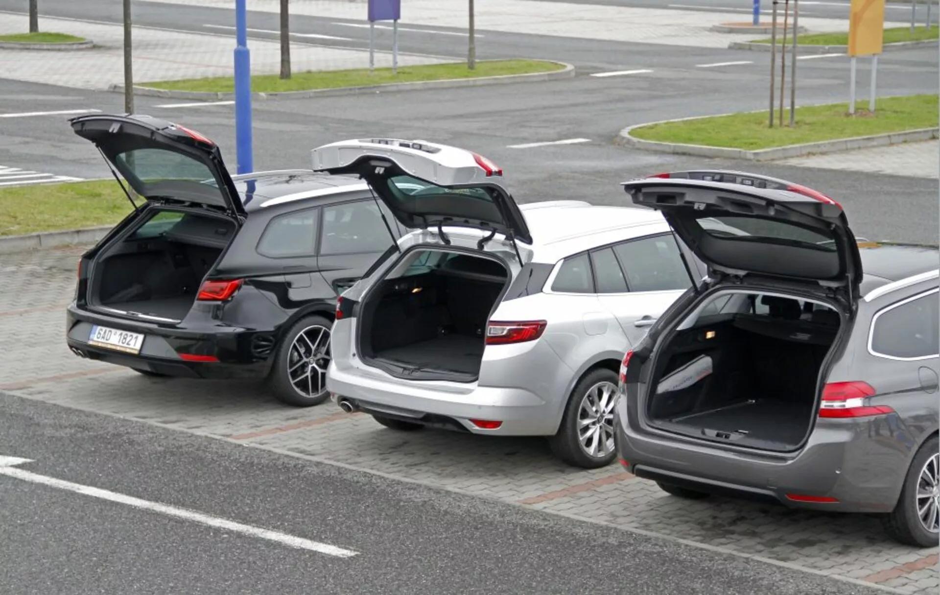 Tre station wagon Peugeot 308 SW 2013 parcheggiati fianco a fianco con portelloni posteriori aperti che evidenziano lo spazio di carico e il design del portellone da un angolo elevato