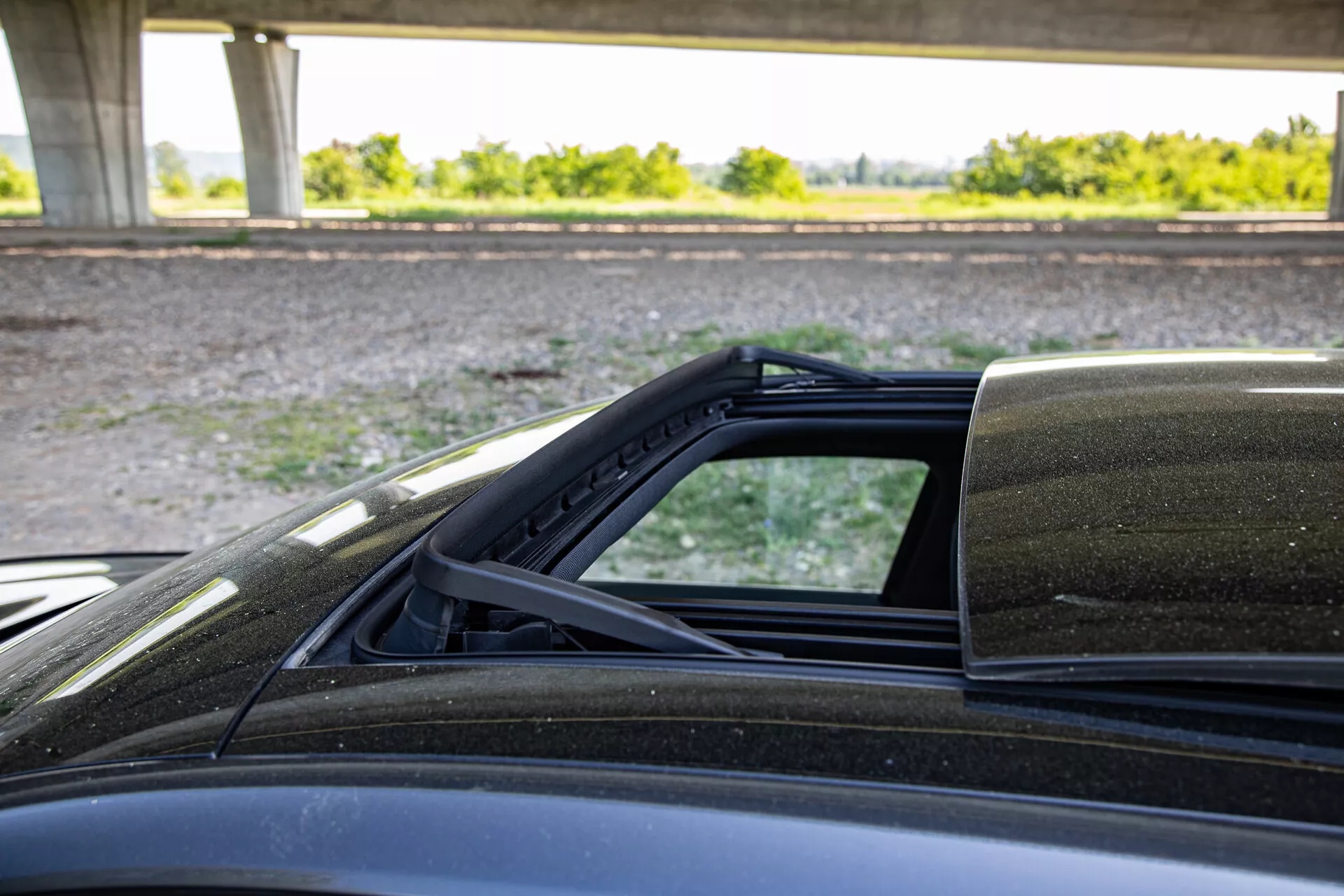 Vista dettagliata del meccanismo del tetto convertibile della Peugeot 408 2023, con focus sui punti di connessione alla carrozzeria, ripresa dal lato passeggero evidenziando la fodera interna del soft top, la sigillatura dagli agenti atmosferici e la verniciatura esterna.