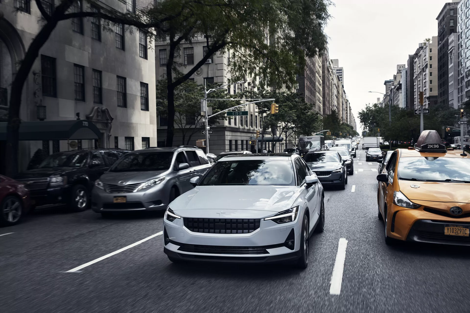 Vista frontale della Polestar 2 2020 di prima generazione in movimento, che mostra il suo design elegante, curve aerodinamiche e fari LED moderni.