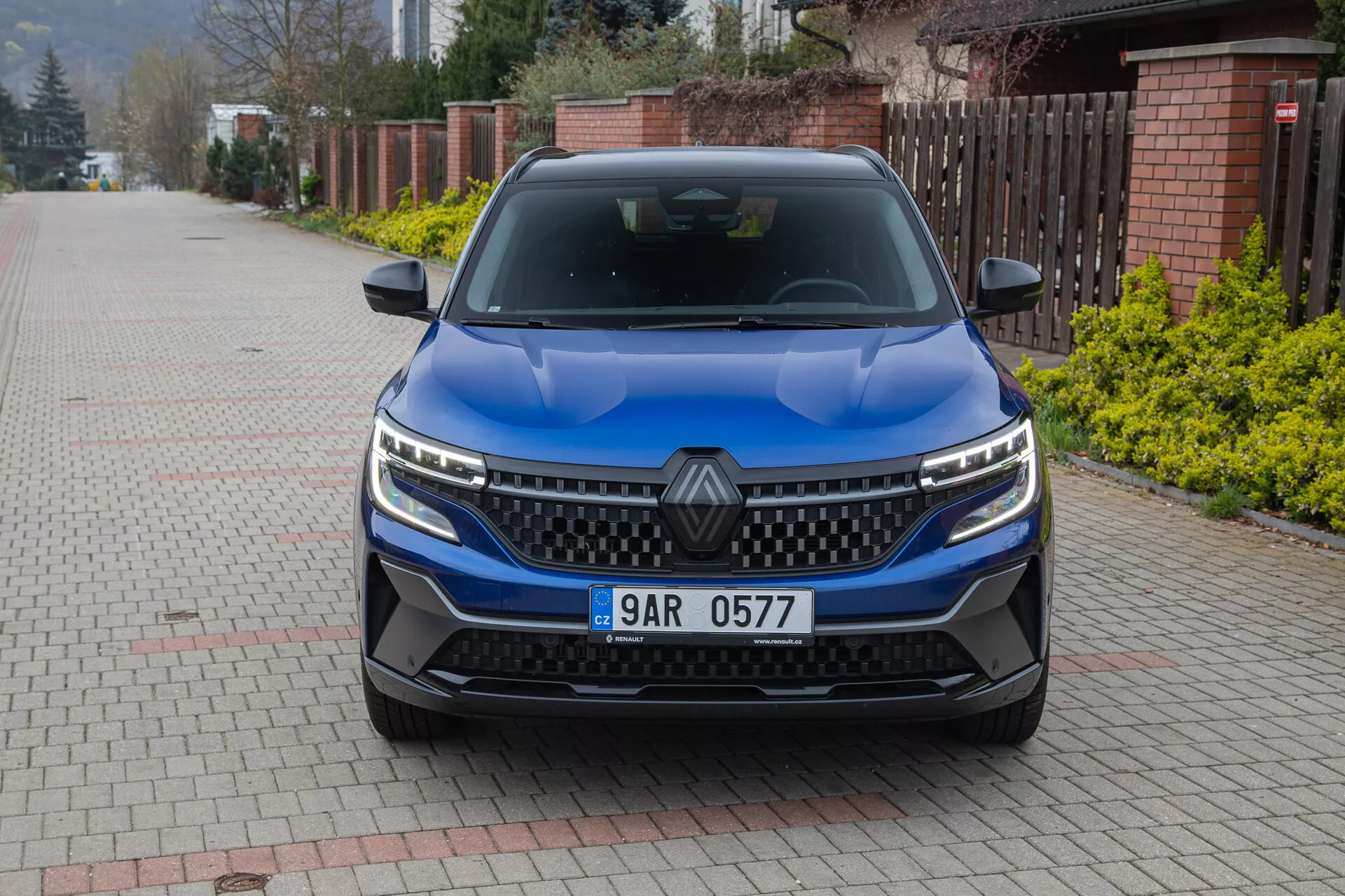 Vista frontale della Renault Austral 2022 con focus sulla griglia, fari LED e design del cofano con finitura blu metallico