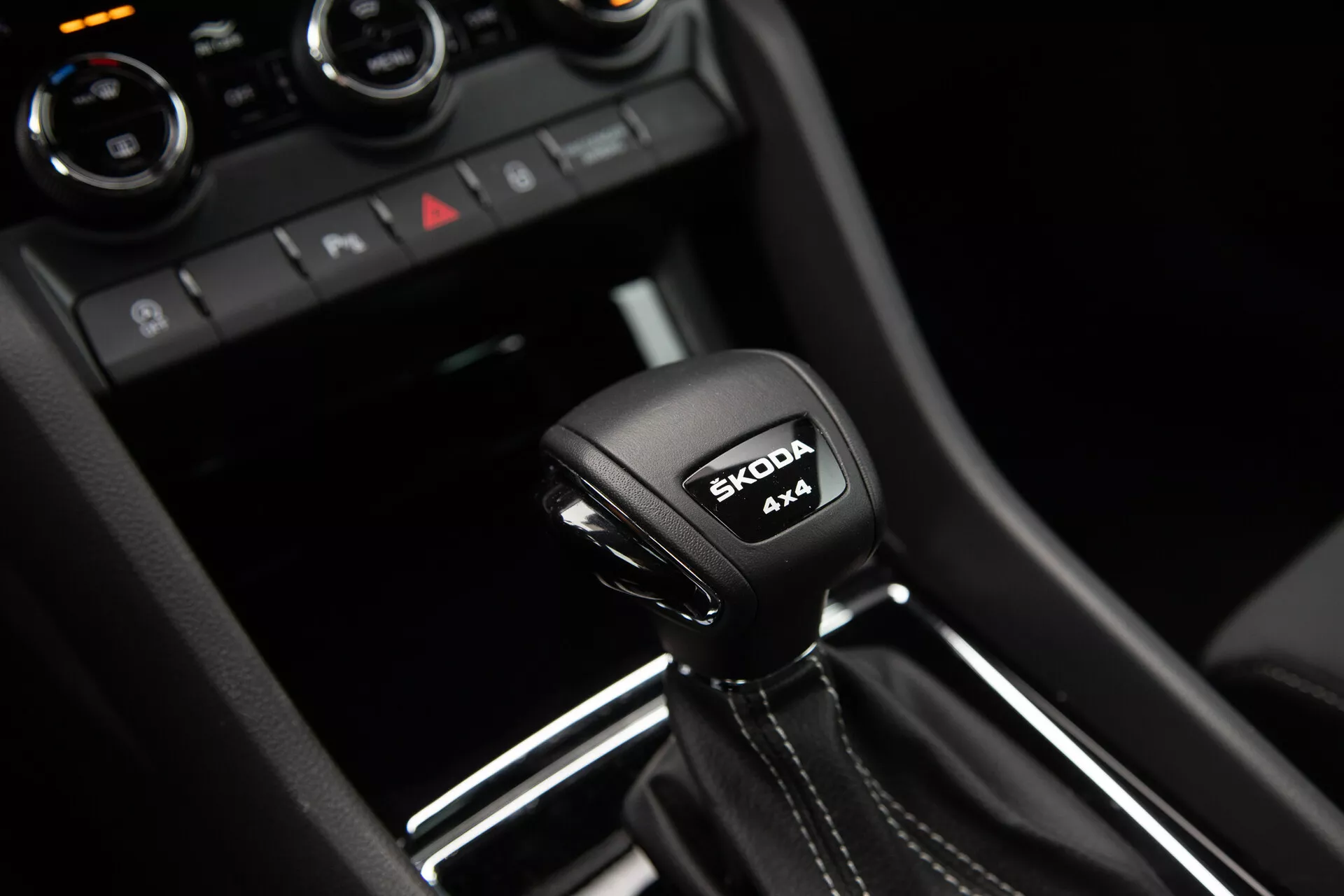 Cambio automatico Škoda Karoq 2021 con iscrizione sistema 4x4 e logo Škoda, circondato da dettagli interni moderni in nero lucido e rifiniture metalliche.