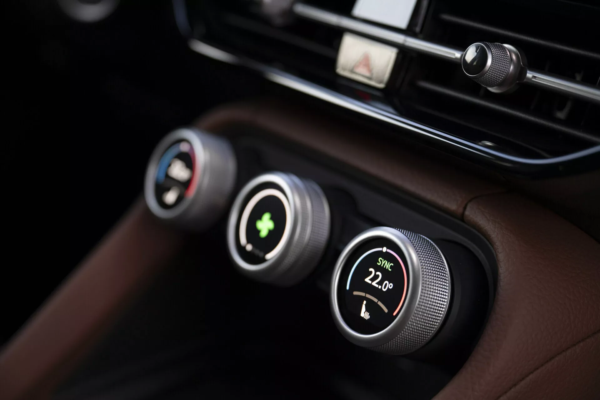 Vista ravvicinata del sistema di controllo del clima della Skoda Kodiaq 2024 con controlli della temperatura a doppia zona con manopole metalliche e display digitali, impostato su una plancia in pelle nera di alta qualità