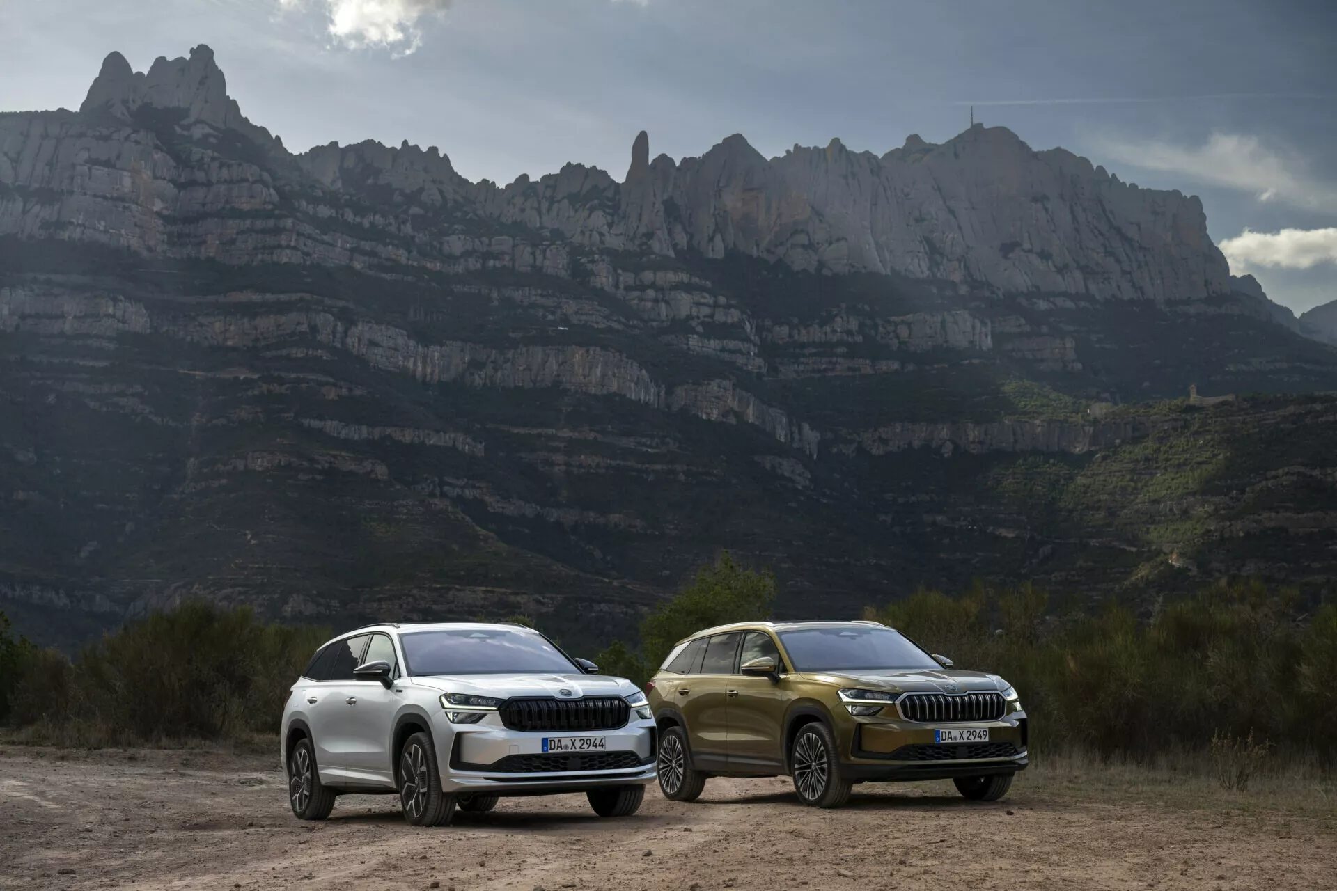 SUV Skoda Kodiaq 2024 con luci LED e dettagli di design di lusso parcheggiati all'aperto contro uno sfondo montuoso, evidenziando caratteristiche aerodinamiche, ruote in lega e tecnologia avanzata adatta alla guida avventurosa.
