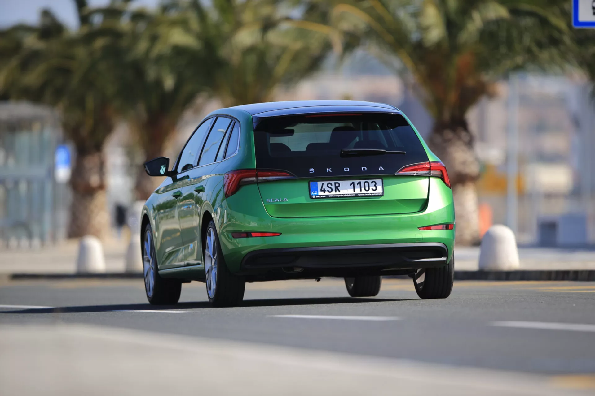 Škoda Scala 2019 in movimento mostrata da una vista posteriore, evidenziando caratteristiche di design moderno come luci posteriori LED, spoiler posteriore integrato e doppie punte di scarico, catturata con una prospettiva dinamica da un angolo basso.